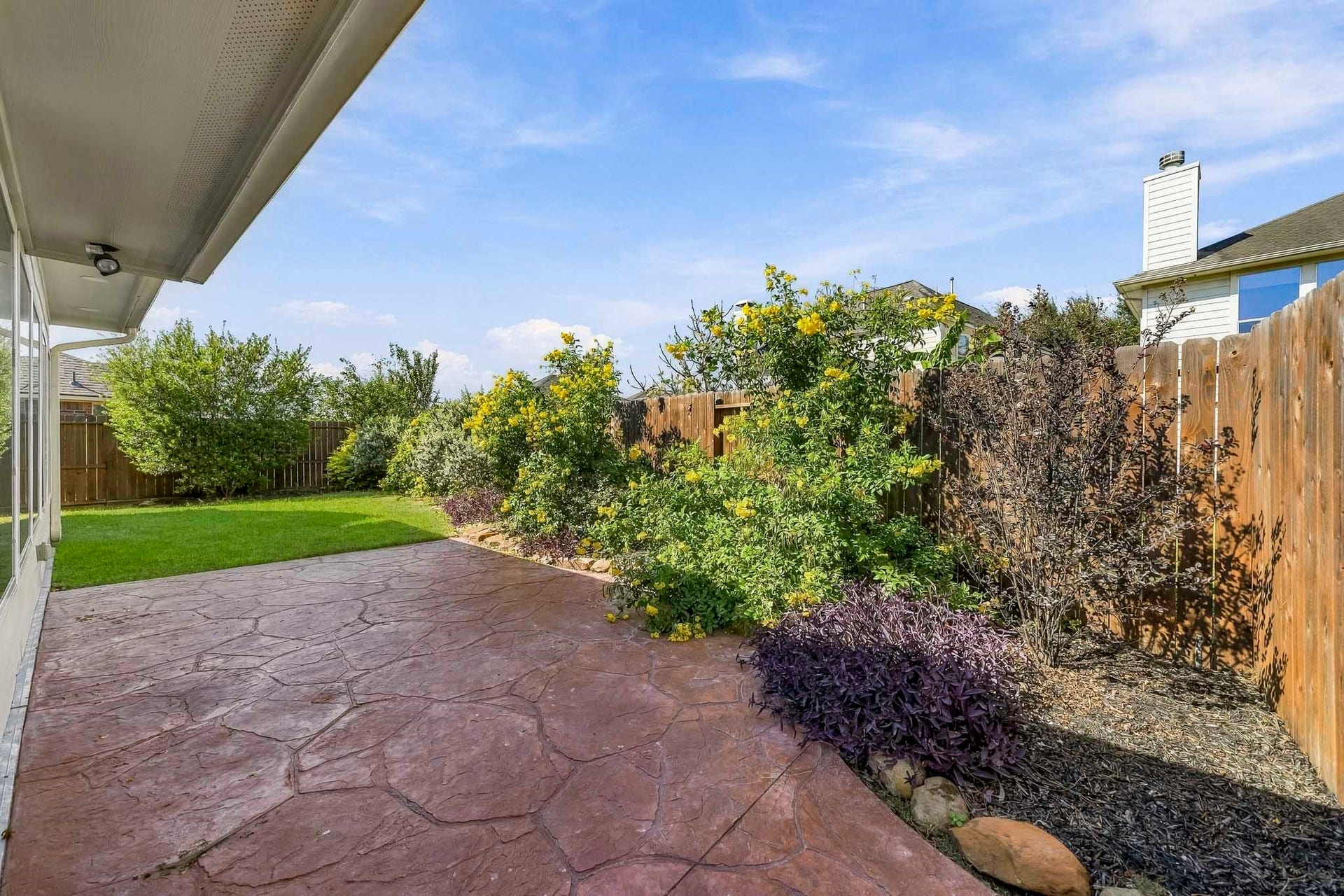 Experience the tranquility of a beautifully maintained, lush landscape that perfectly frames this inviting patio space, offering a serene retreat right at home.