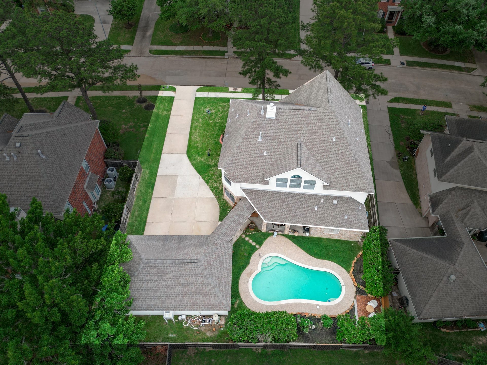 15627 Twisting Springs Drive, Cypress, TX 77433 Spacious suburban home with a large driveway and charming backyard pool, surrounded by lush greenery and well-maintained landscaping.