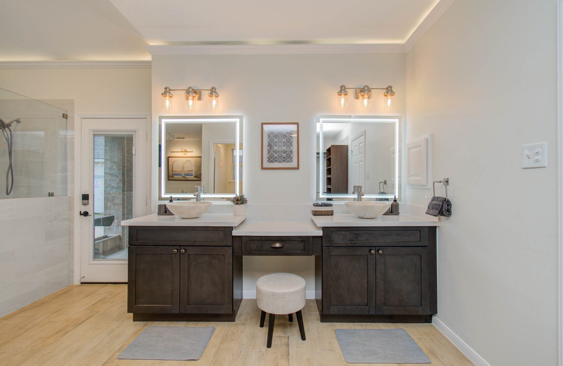 15627 Twisting Springs Drive, Cypress, TX 77433 Elegant bathroom featuring dual vessel sinks, modern illuminated mirrors, and stylish dark cabinetry, offering a spa-like retreat.