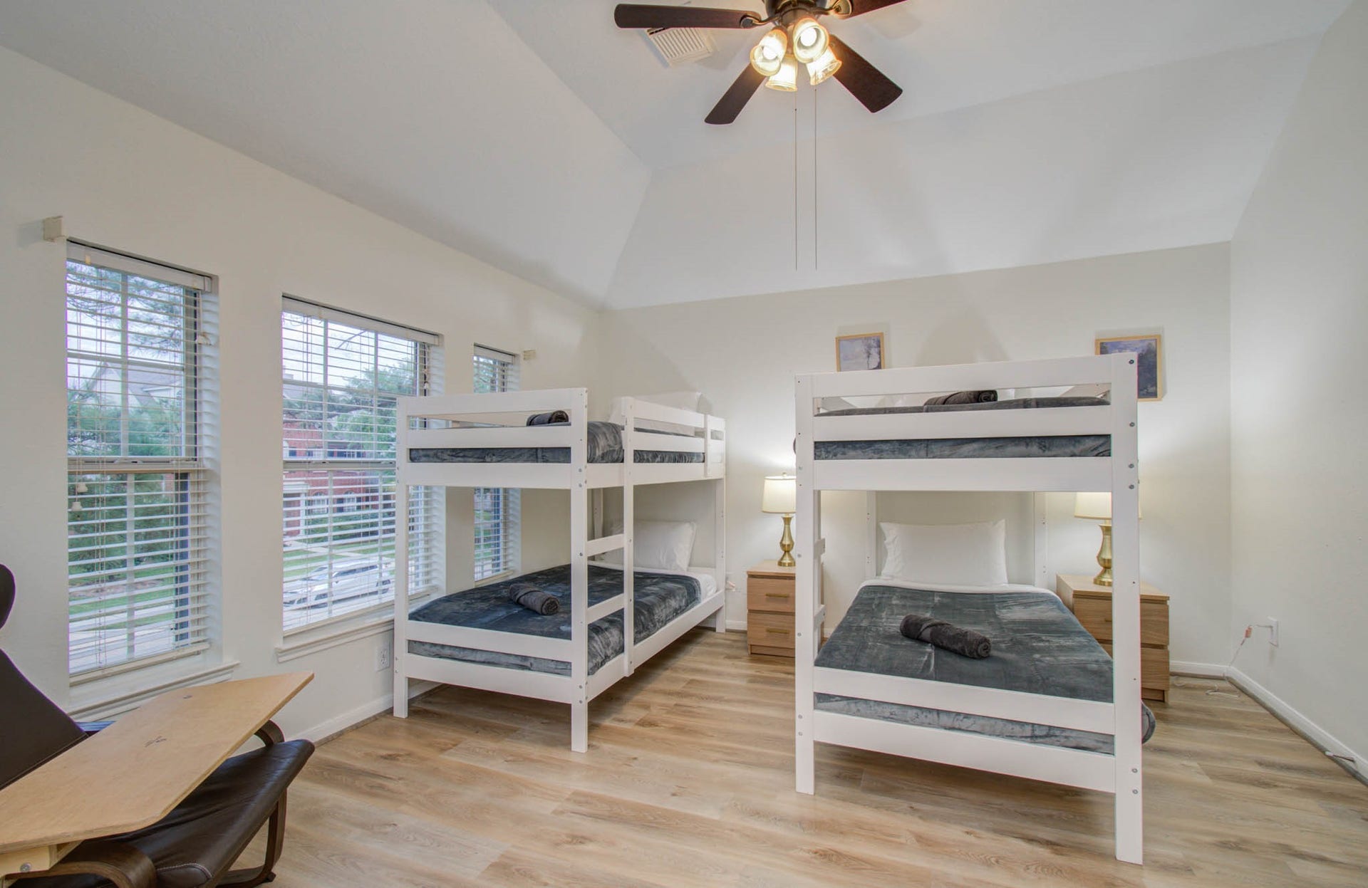 15627 Twisting Springs Drive, Cypress, TX 77433 Spacious bedroom featuring two sets of modern bunk beds, large windows for natural light, and elegant hardwood flooring.