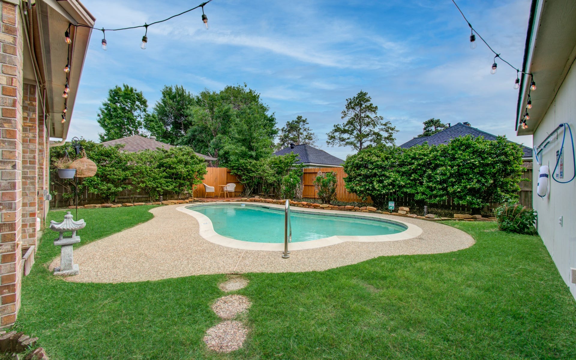 15627 Twisting Springs Drive, Cypress, TX 77433 Charming backyard oasis features a sparkling pool surrounded by lush greenery, perfect for relaxation and entertaining.