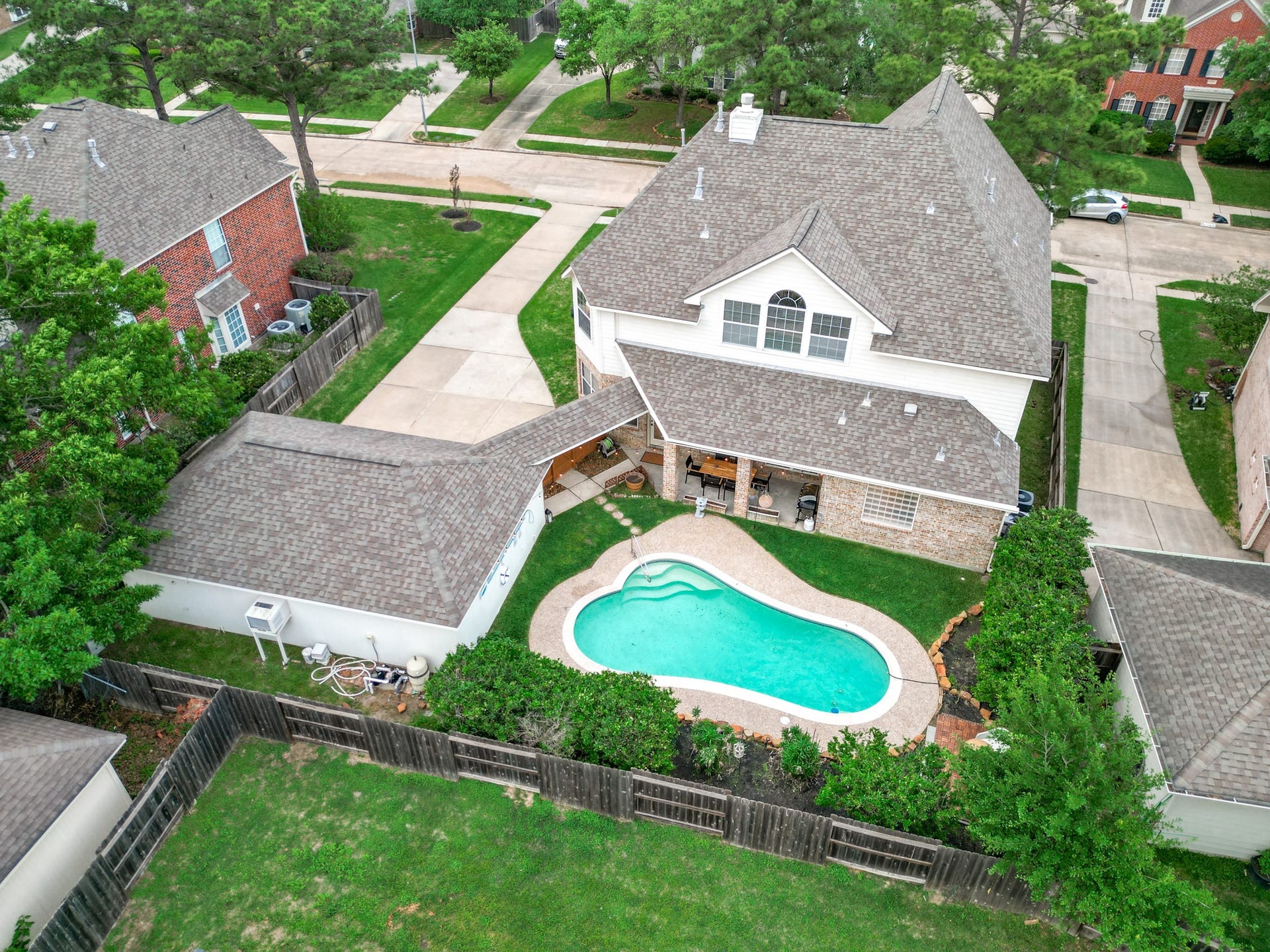 15627 Twisting Springs Drive, Cypress, TX 77433 Charming two-story home with a spacious backyard featuring a pristine swimming pool, surrounded by lush greenery and privacy fencing, perfect for outdoor entertaining.