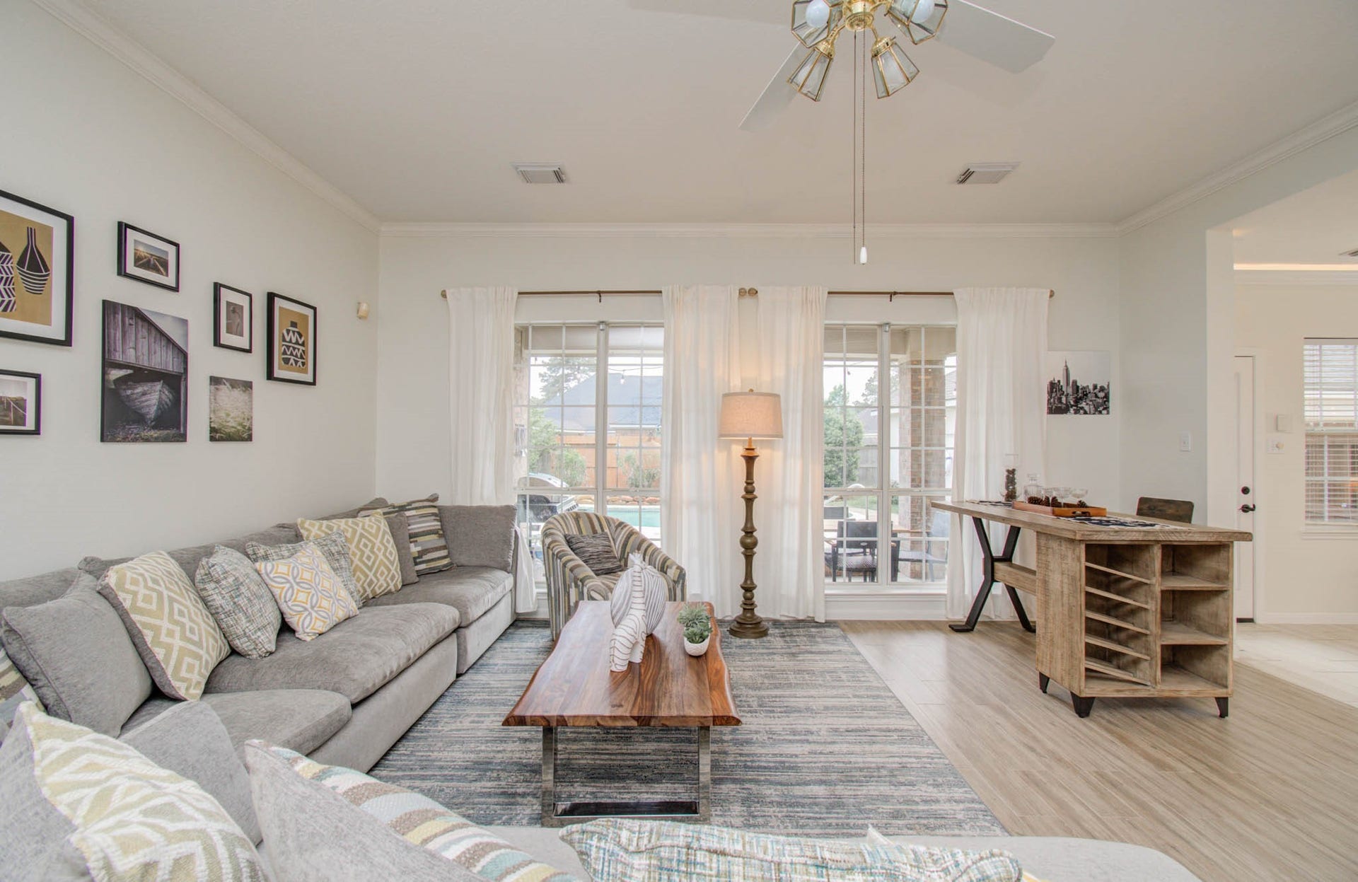 15627 Twisting Springs Drive, Cypress, TX 77433 Bright and inviting living room with large windows, stylish dcor, and a cozy sectional sofa, perfect for relaxation and entertaining.