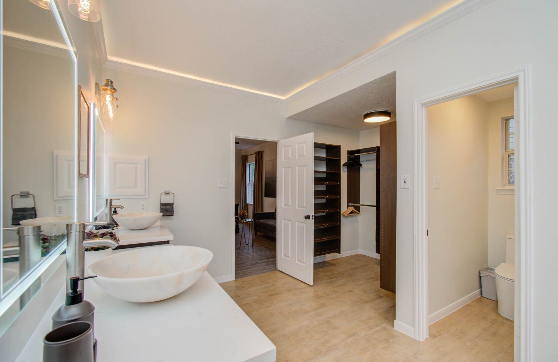 15627 Twisting Springs Drive, Cypress, TX 77433 Elegant bathroom with dual vessel sinks, modern fixtures, and a spacious walk-in closet, offering a blend of style and functionality.