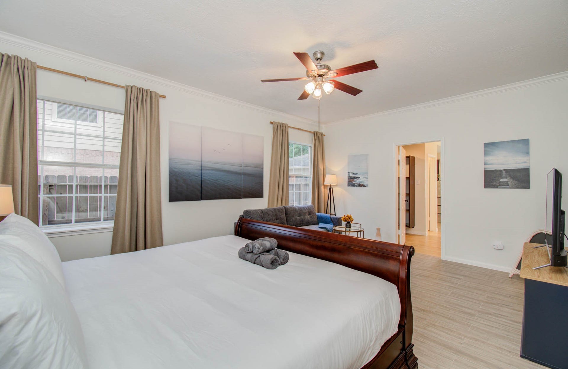 15627 Twisting Springs Drive, Cypress, TX 77433 Spacious bedroom featuring a luxurious sleigh bed, elegant ceiling fan, and ample natural light through large windows with tasteful drapery.
