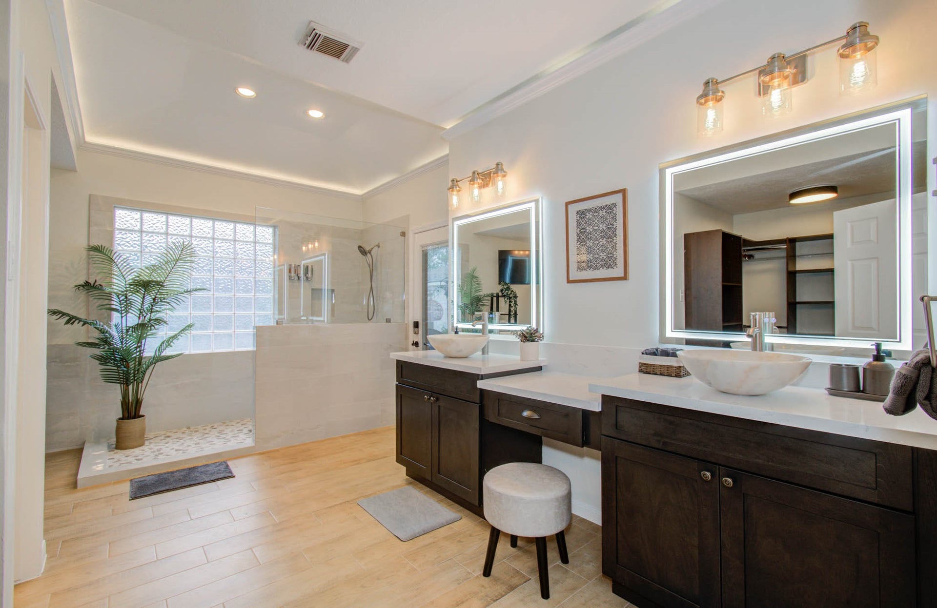 15627 Twisting Springs Drive, Cypress, TX 77433 Luxurious bathroom featuring dual vessel sinks, sleek cabinetry, and a spacious walk-in shower with elegant glass block accents, creating a serene and modern retreat.