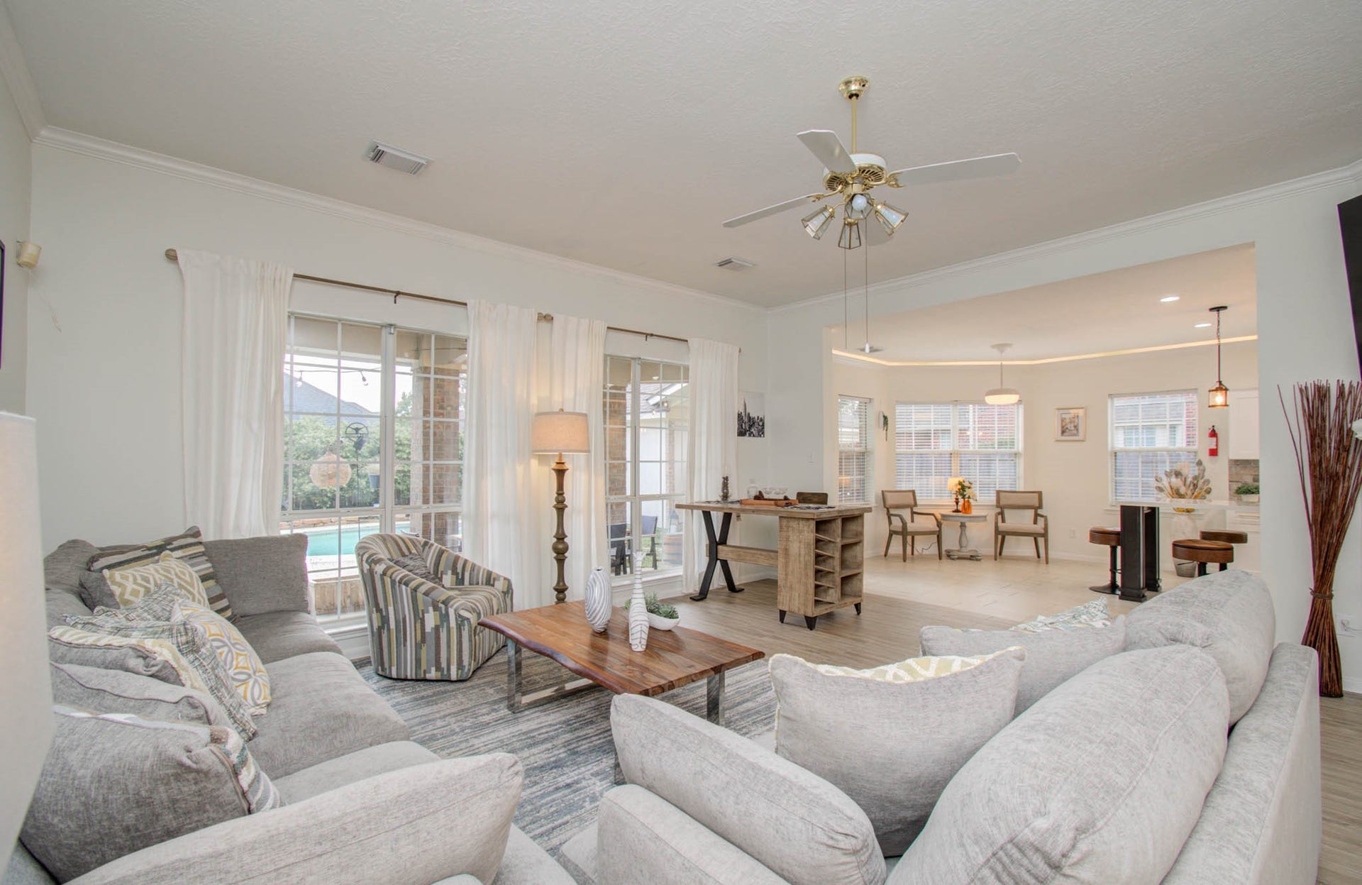 15627 Twisting Springs Drive, Cypress, TX 77433 Spacious living area with cozy seating, abundant natural light, and an open layout leading to a bright dining space, perfect for entertaining.