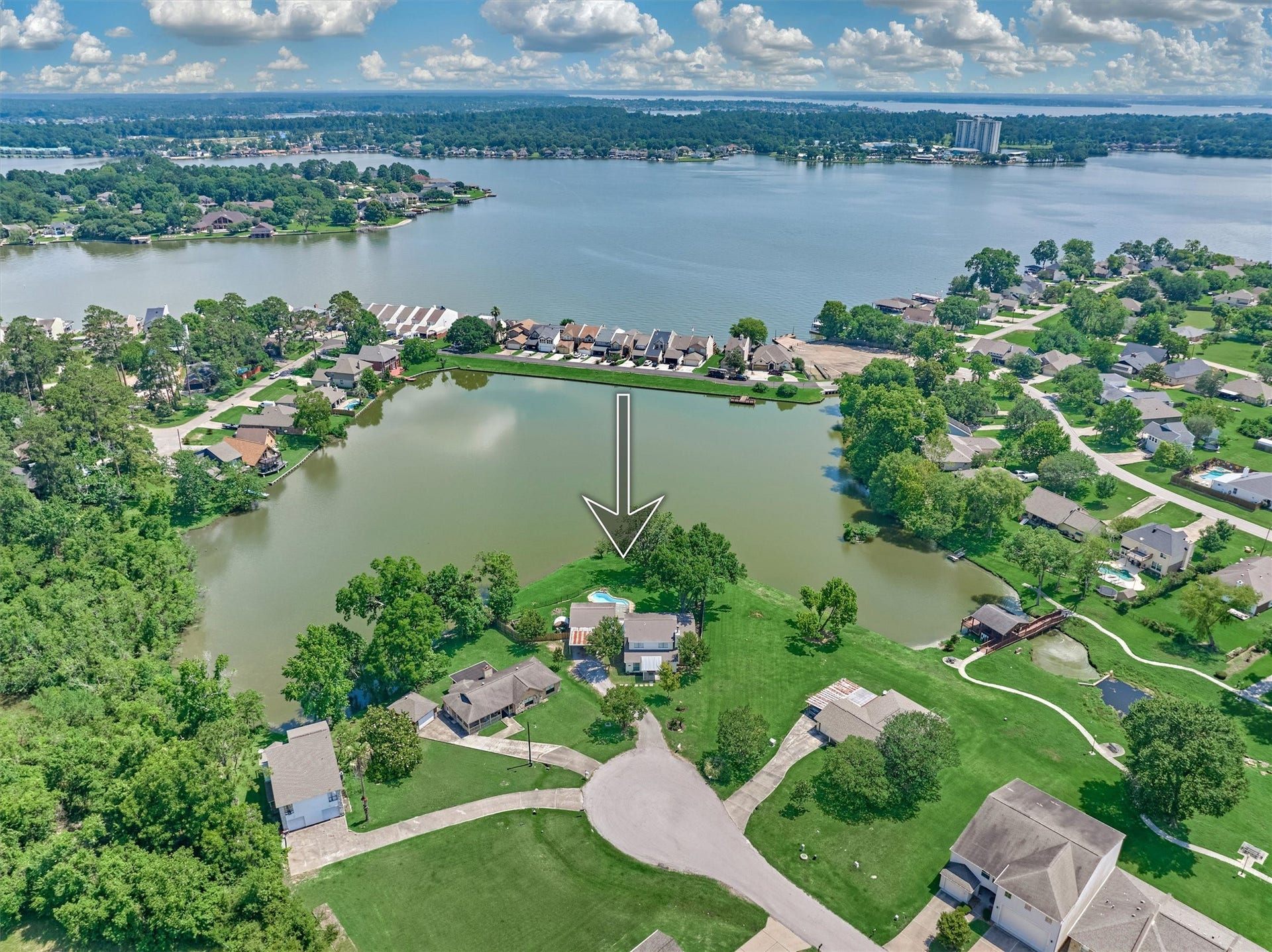 438 Lazy Lane, Montgomery, TX 77356 From above, the propertys exceptional setting comes to life, expansive green space, mature trees, sparkling water, and room to breathe.