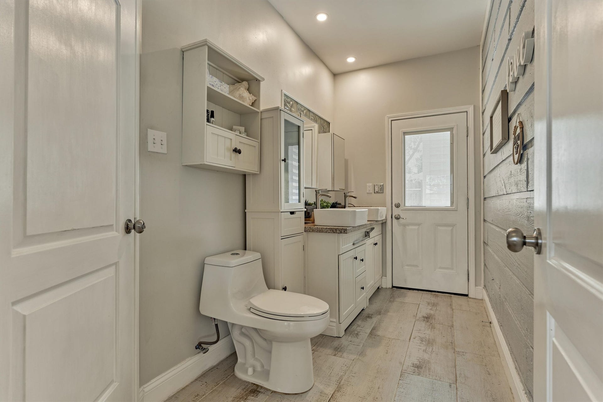 438 Lazy Lane, Montgomery, TX 77356 The spacious primary bath offers tiled floors, dual sinks and a feature wall, blending comfort and style.