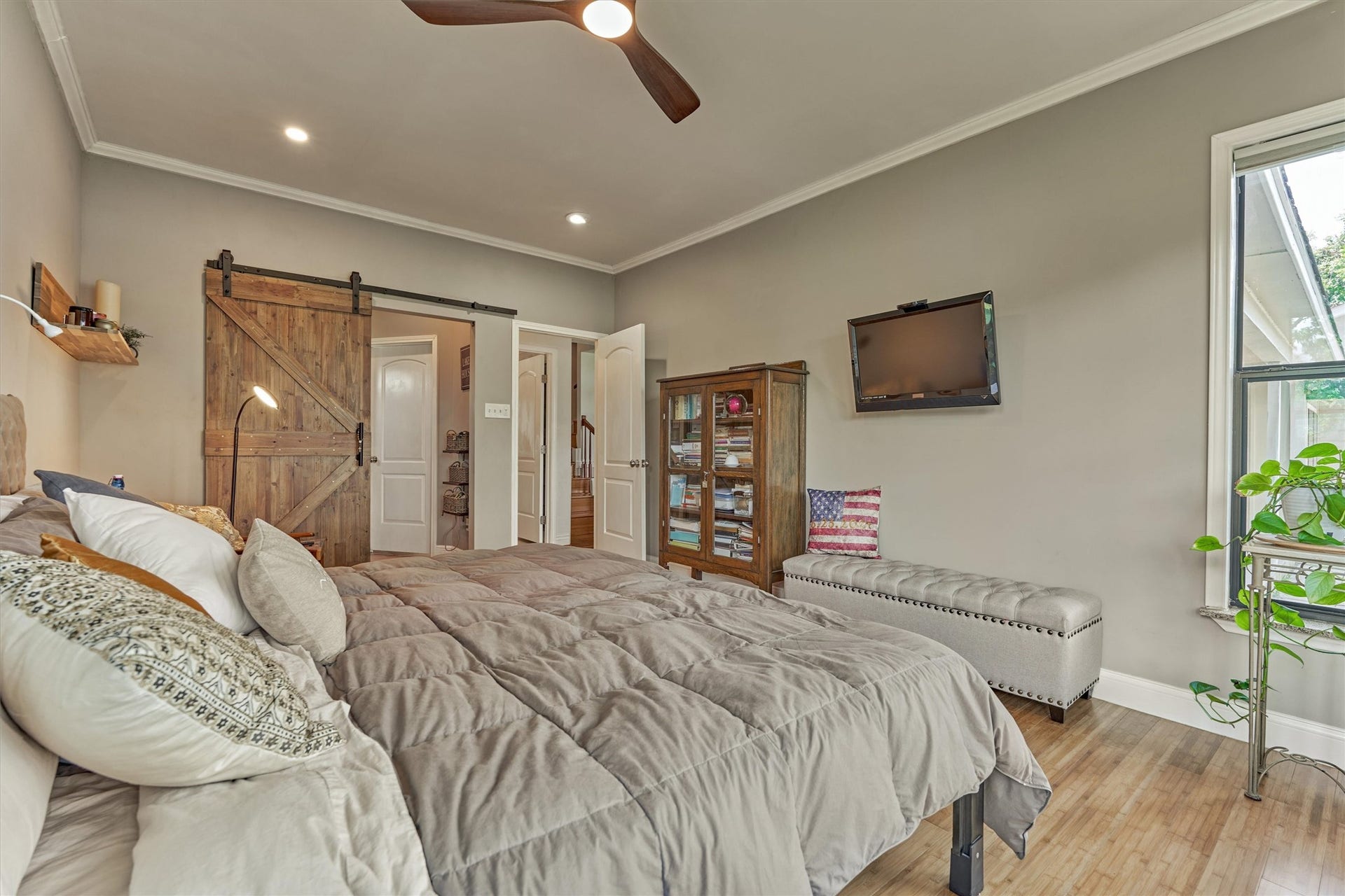 438 Lazy Lane, Montgomery, TX 77356 The spacious primary suite comes complete with a stunning custom sliding barn door that leads to the closet and primary bath.