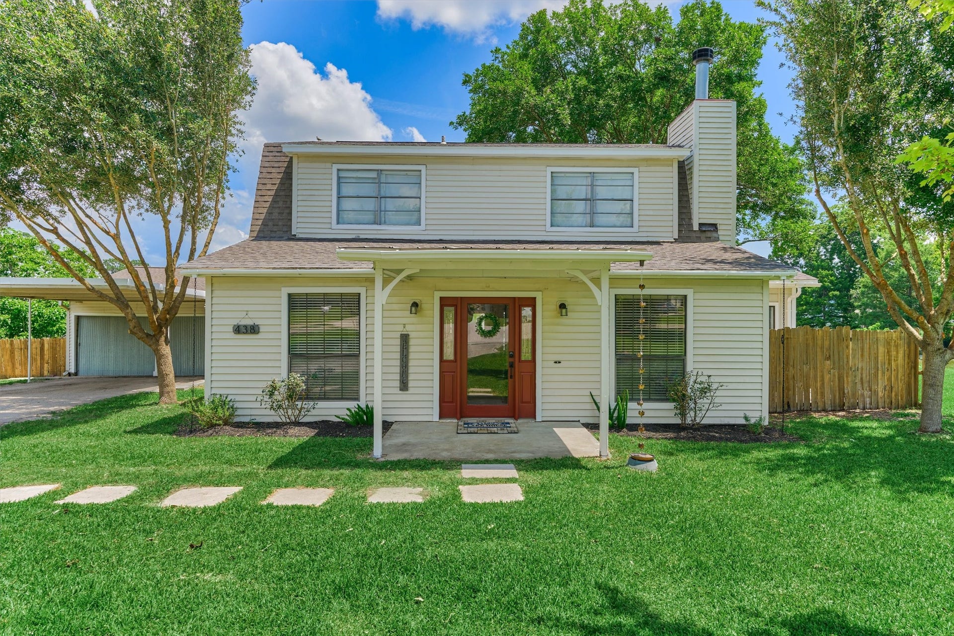 438 Lazy Lane, Montgomery, TX 77356 The welcoming covered front porch is highlighted by a stunning custom wood and glass entry door, creating a welcoming first impression.