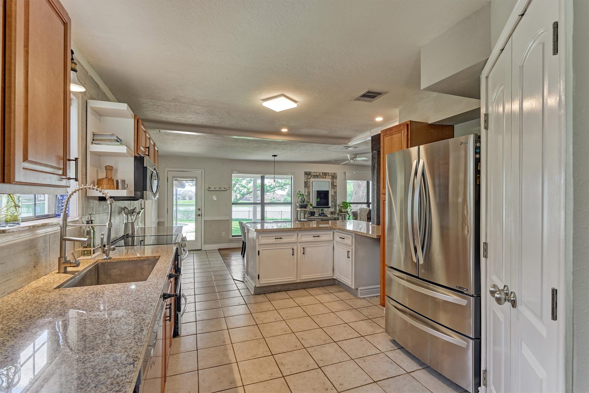 438 Lazy Lane, Montgomery, TX 77356 Looking back from the formal dining through the kitchen the home flows seamlessley to your backyard retreat.