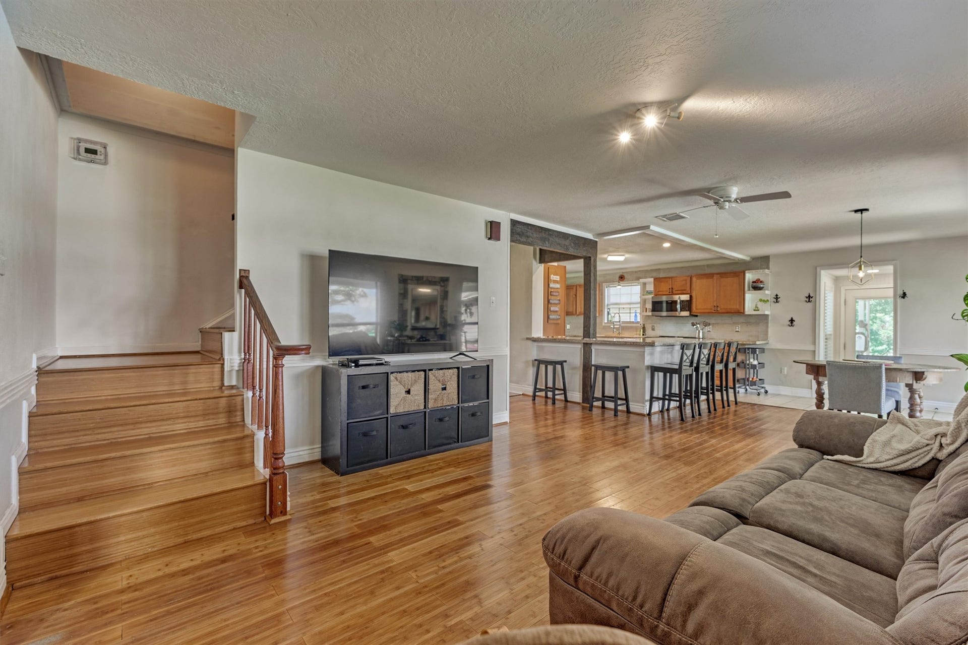 438 Lazy Lane, Montgomery, TX 77356 Rich bamboo floors guide you through this open-concept living space, seamlessley connecting the living area, breakfast room, kitchen, and upstairs to the secondary rooms.