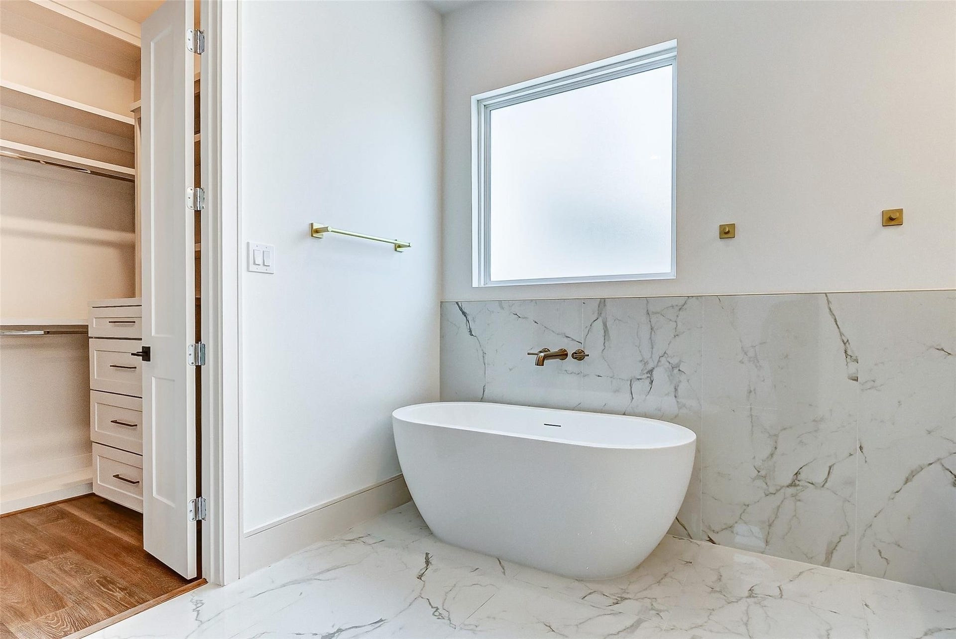 605 E 26th A Street, Houston, TX 77008 Large freestanding soaking tub beneath a window providing natural light without compromising privacy.