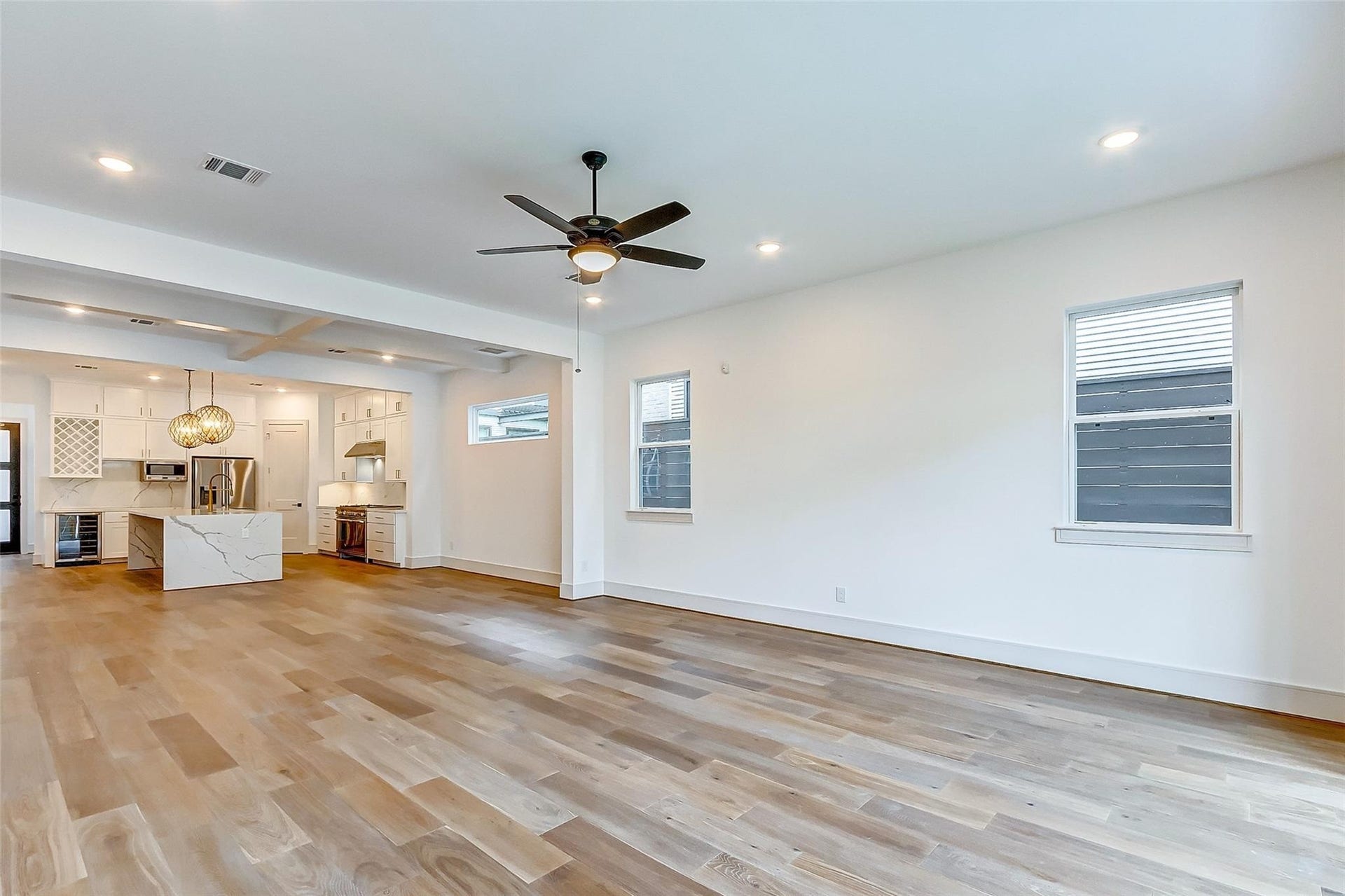 605 E 26th A Street, Houston, TX 77008 This family room/living room sits adjacent to the kitchen and is SPACIOUS! Features include designer paint, tall ceilings, a modern ceiling fan, bright windows, and hardwood floors.
