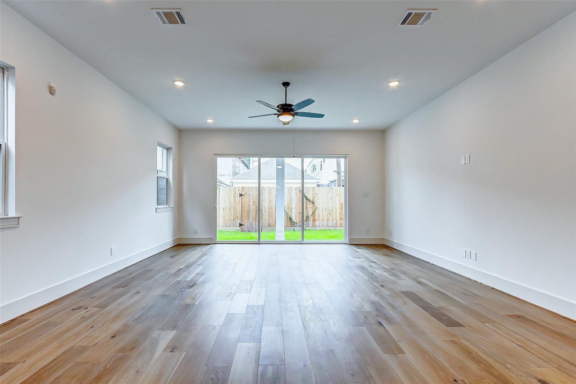 605 E 26th A Street, Houston, TX 77008 The spacious living room opens up to the private fenced backyard through large sliding glass doors.