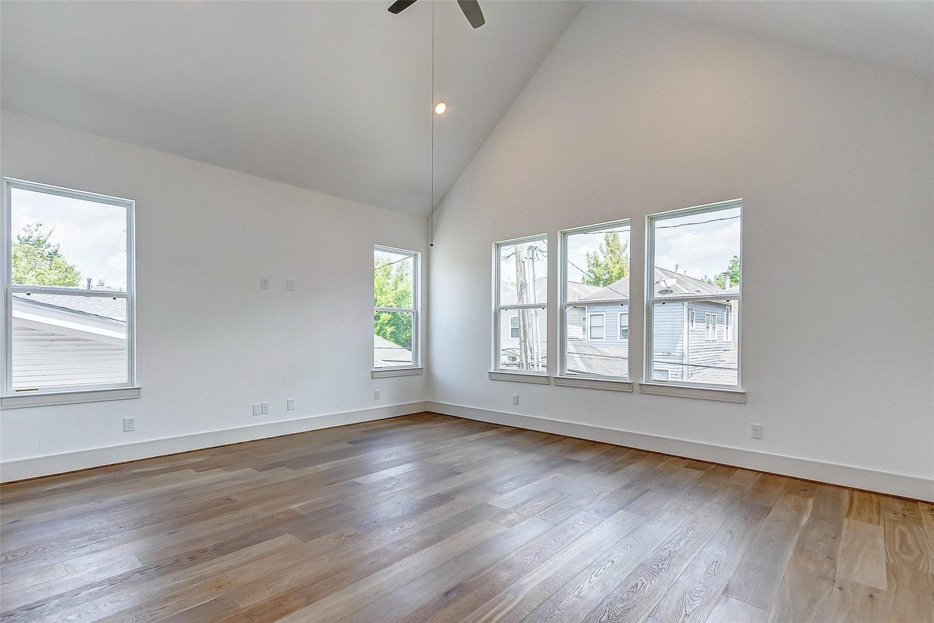 605 E 26th A Street, Houston, TX 77008 Spacious primary suite featuring high vaulted ceilings, abundant natural light through multiple windows, elegant hardwood flooring, and a stunning ensuite spa like bathroom.