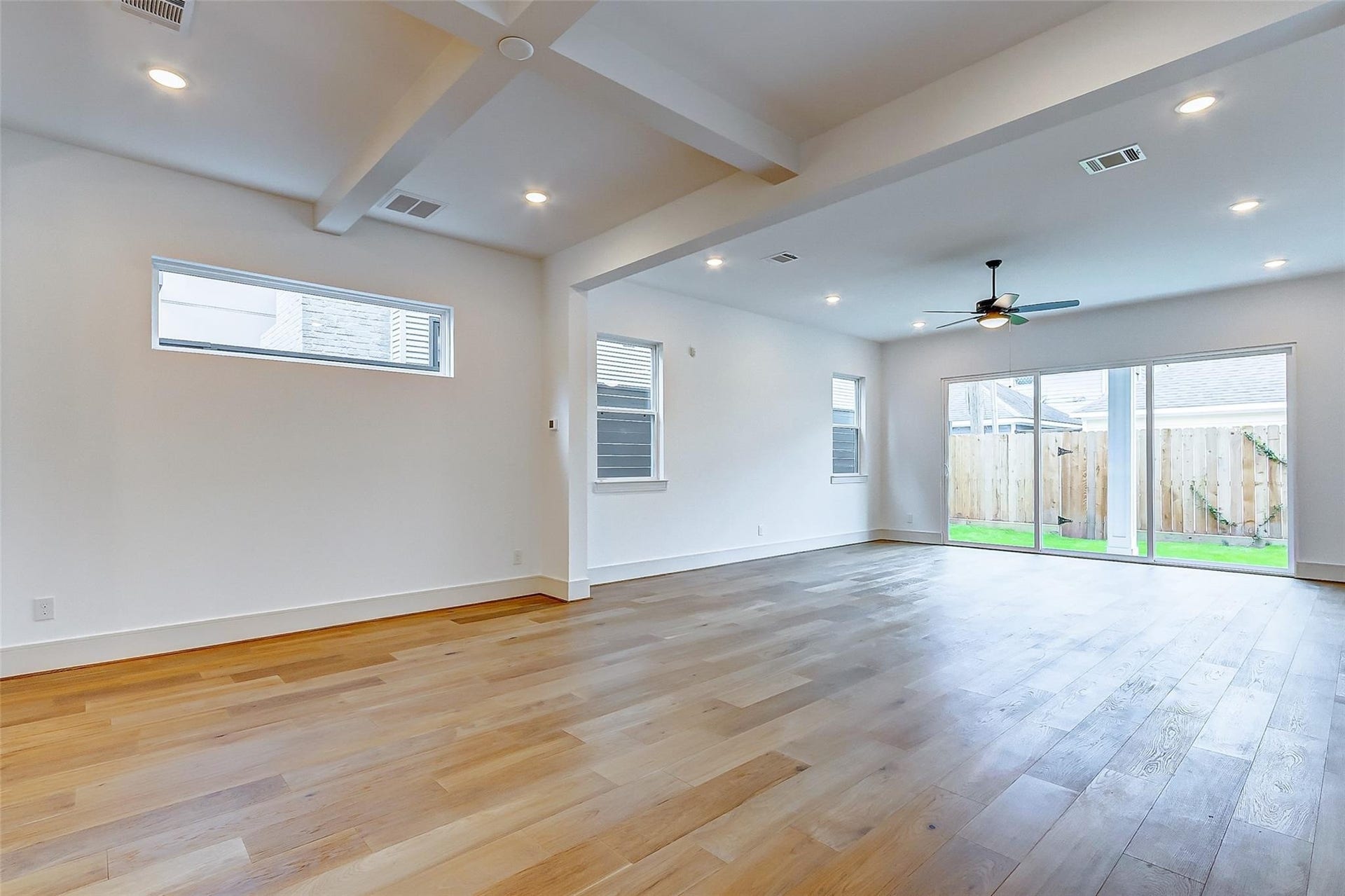605 E 26th A Street, Houston, TX 77008 Spacious open-concept living area with elegant hardwood floors, recessed lighting, and abundant natural light from large sliding glass doors leading to the backyard/patio.