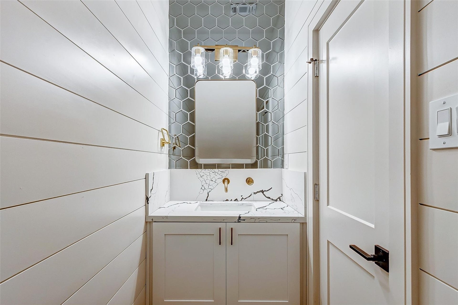 605 E 26th A Street, Houston, TX 77008 Sophisticated powder room/ guest bathroom with elegant shiplap walls, a chic hexagonal tile backsplash, and a modern vanity featuring a sleek quartz countertop.
