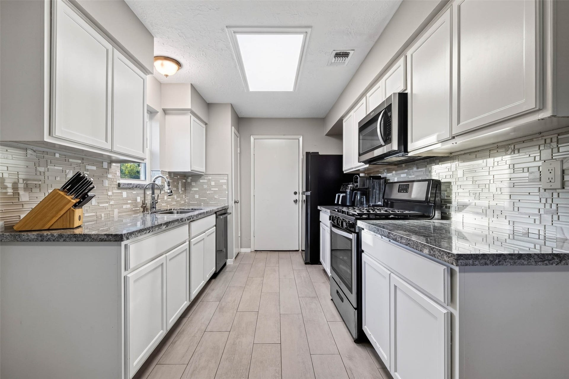 Kitchen with stainless steel appliances and granite countertops. The window provides a lot of natural light.