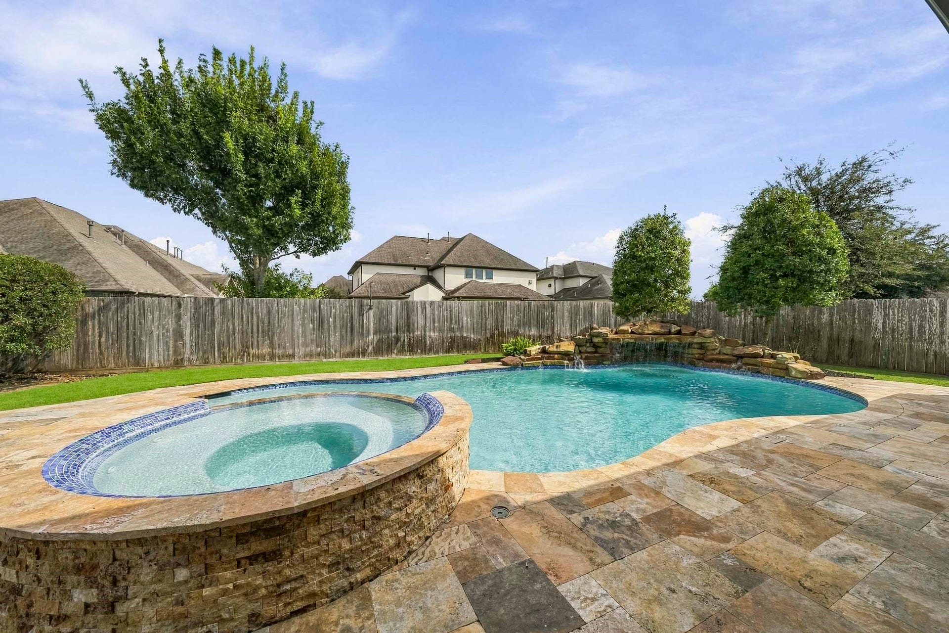 Gotto with waterfall, Raised hottub with rounded neck edging for comfort. Patio has gas line access in a couple places.