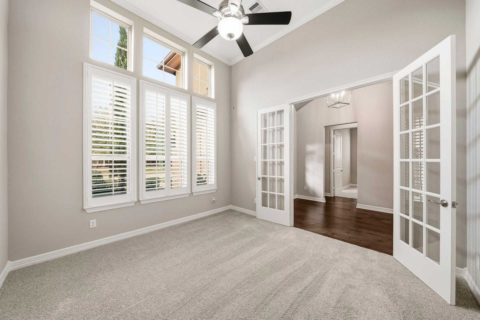 High ceilings with fan, crown molding and plantation shutters.