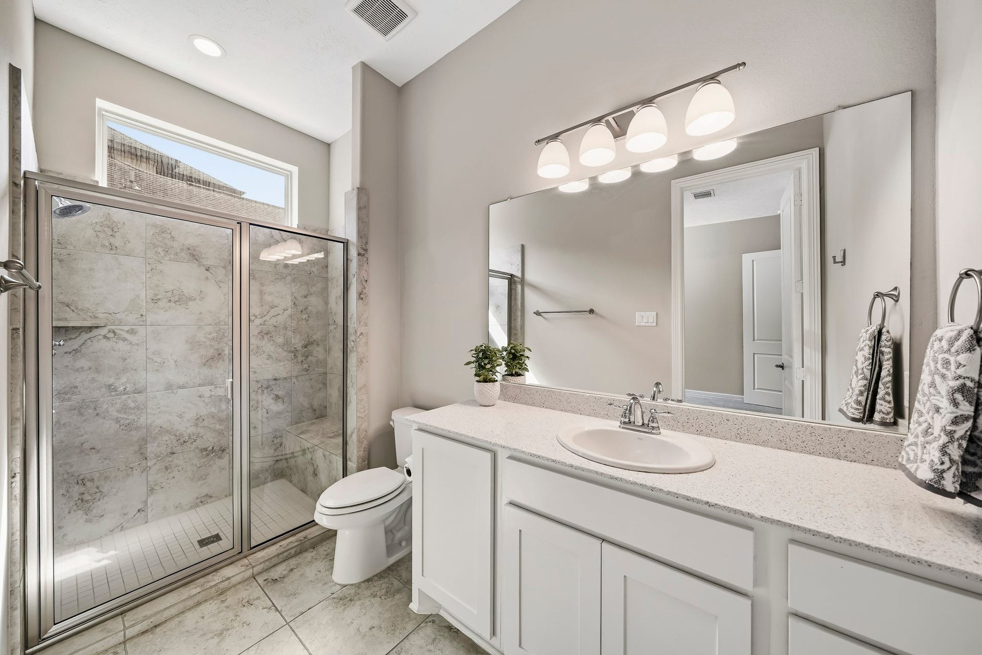 En-suite bathroom has large vanity, large walk-in shower with seat.