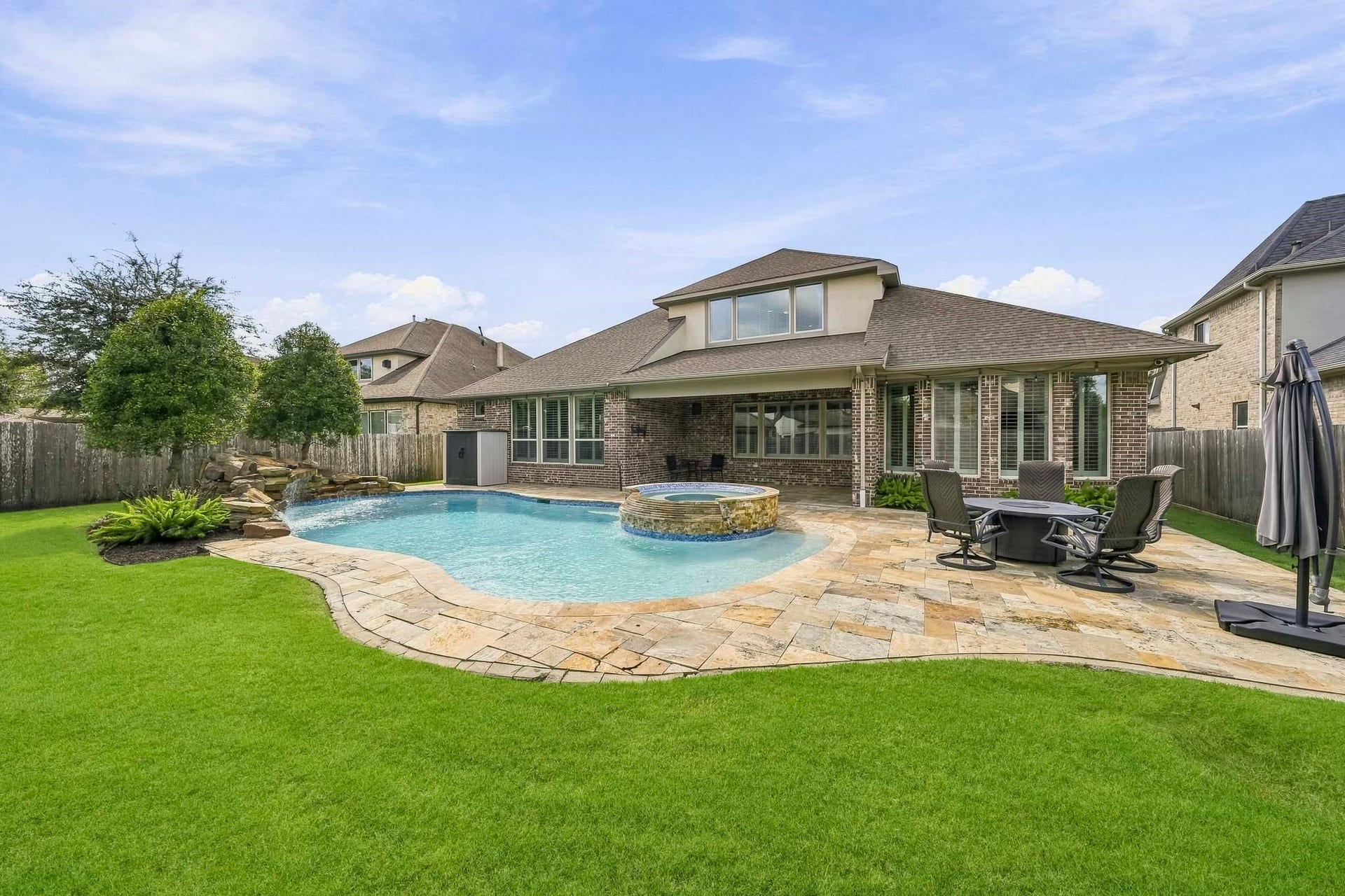 You could enjoy this backyard all year. Heated pool, raised spa and a grotto waterfall.