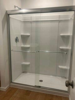 Sleek glass-enclosed shower with built-in shelving, perfect for a modern bathroom.