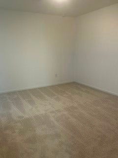 Spacious room with neutral walls and plush carpeting, perfect for creating a cozy retreat.