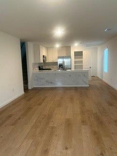 Spacious open-concept living area with hardwood floor on the first floor