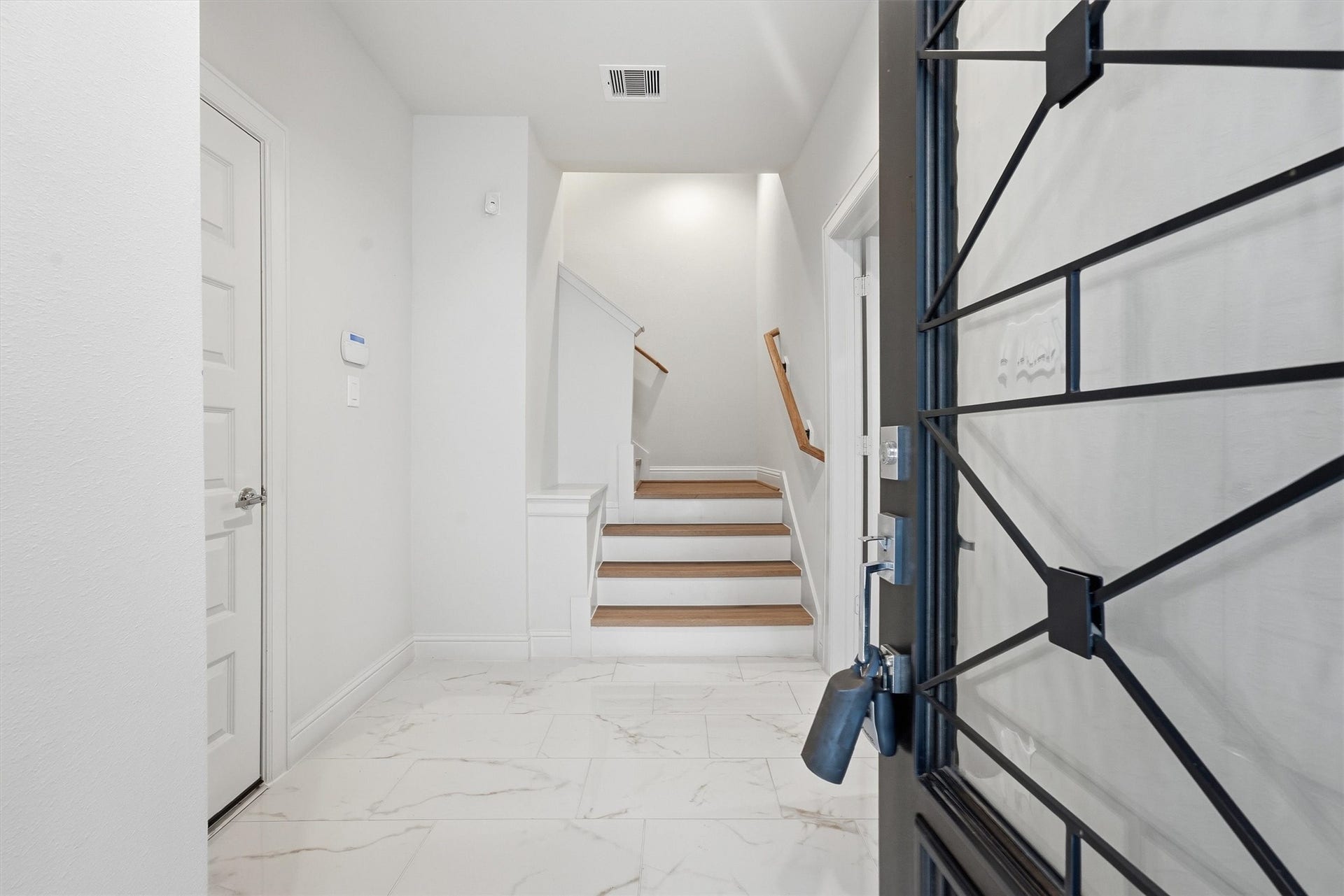 1804 Elysian Street, Houston, TX 77026 Enter a realm of elegance through this bright and inviting entrance, where sleek tile flooring and a welcoming staircase set an exquisite tone for the home.