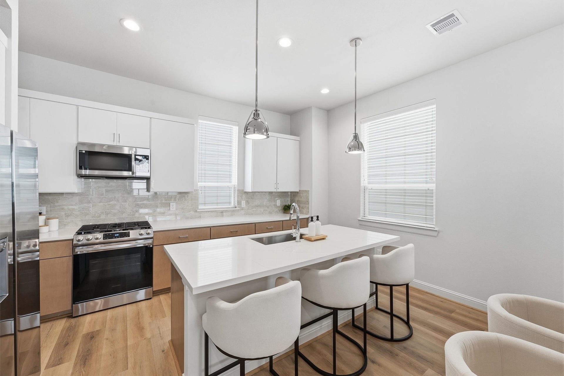 1804 Elysian Street, Houston, TX 77026 Experience culinary excellence in this sleek, modern kitchen with a spacious island for seating, stainless steel appliances, and elegant pendant lighting, perfect for cooking and entertaining.