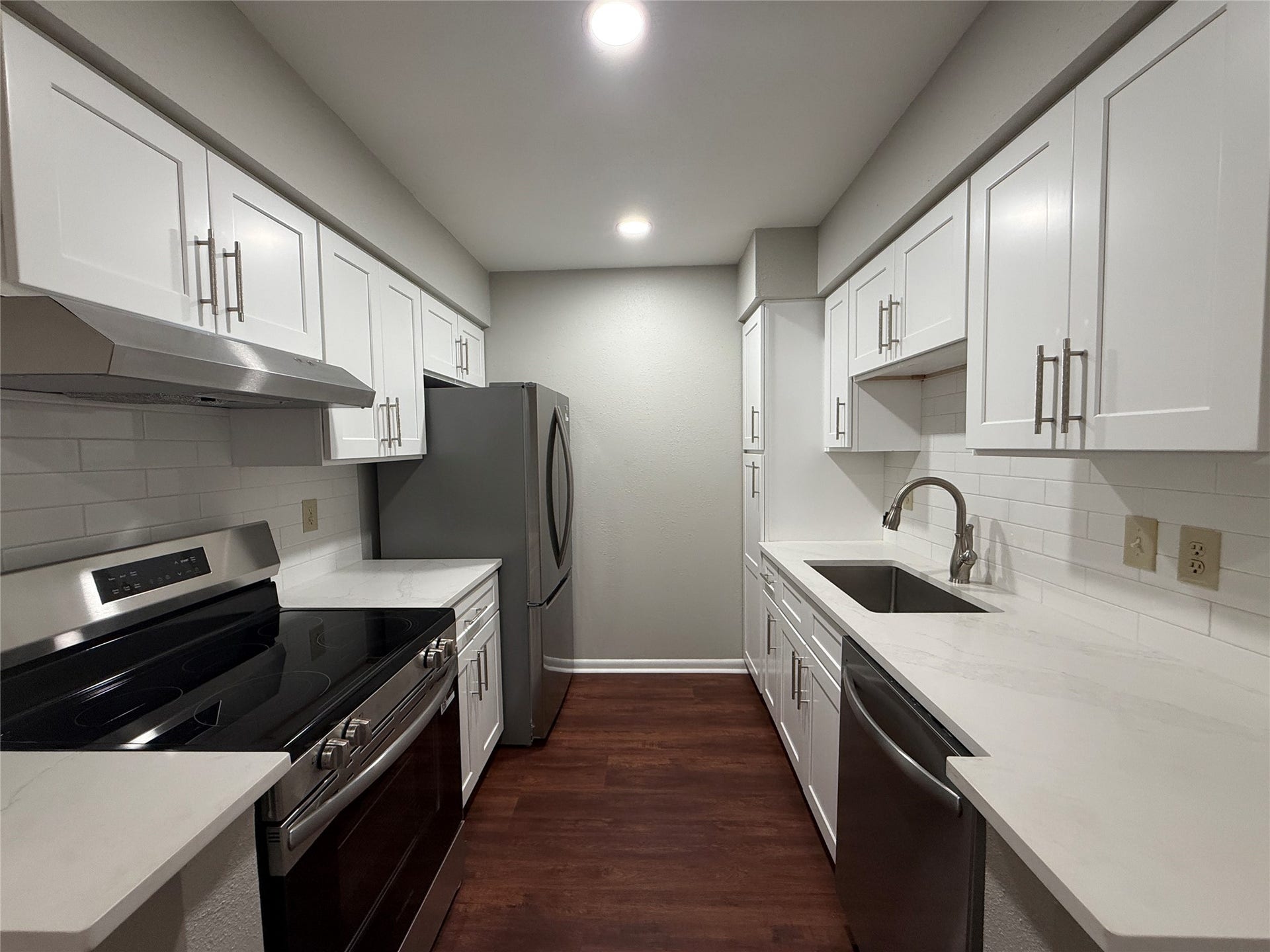 2250 Bering Drive, #40, Houston, TX 77057 Beautifully updated galley kitchen featuring white shaker-style cabinetry, subway tile backsplash, and stainless steel appliances.
