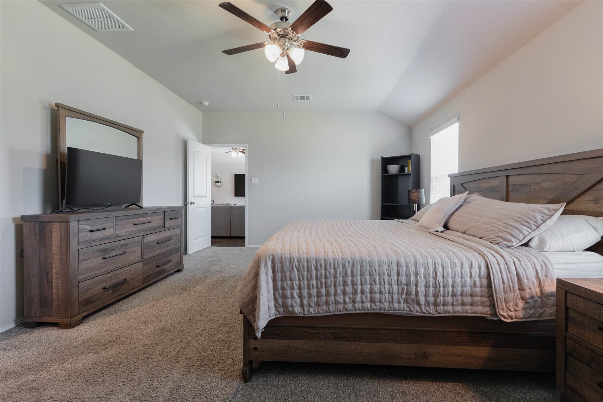15303 Dinnet Berm Drive, Humble, TX 77346 This second angle shows just how generously sized the primary suite is. A king size bedroom set fits with space to spare, leaving room for a dresser, a media setup, and extra furnishings. The suite also sits conveniently close to the main living area.