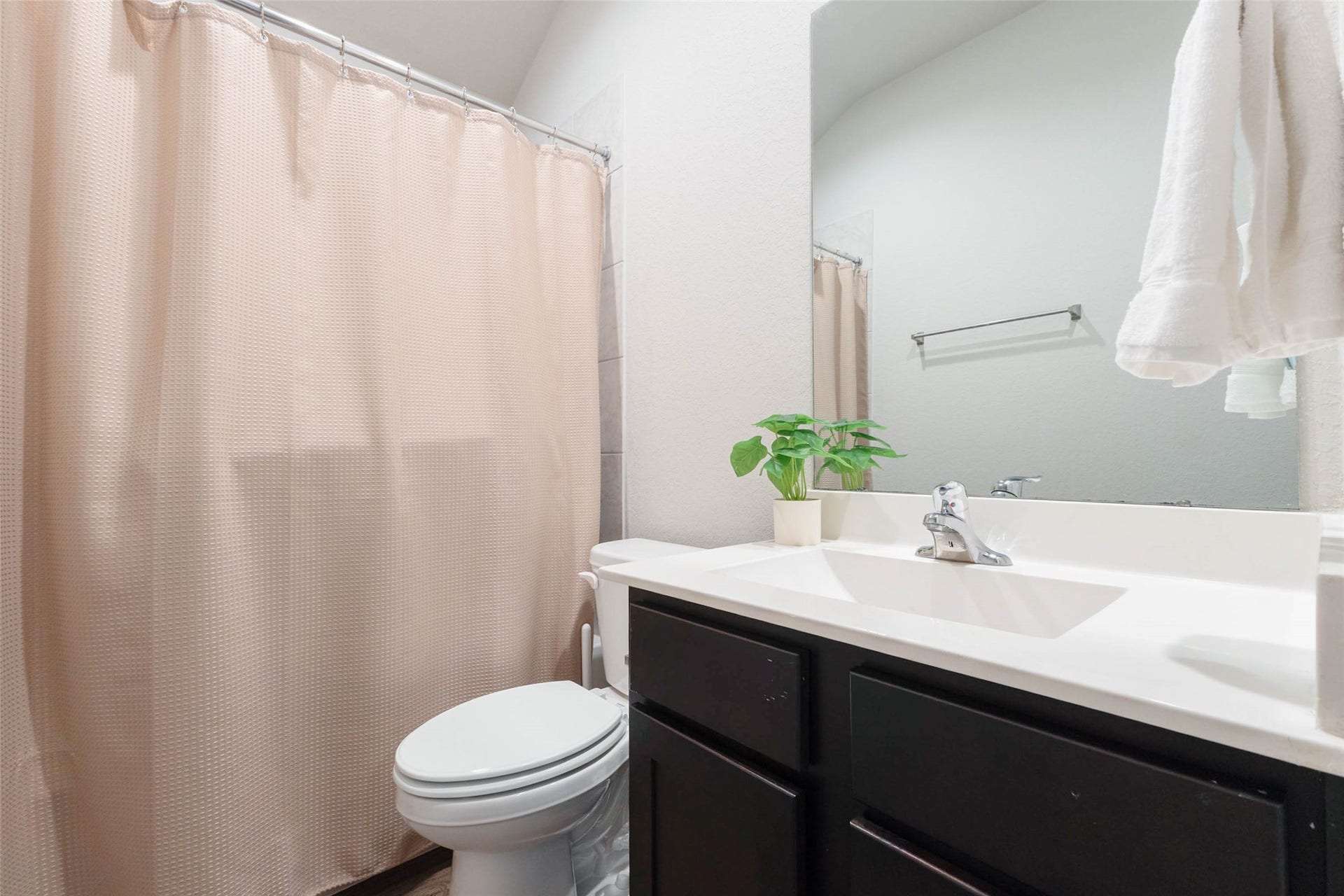 15303 Dinnet Berm Drive, Humble, TX 77346 Guests will love this clean and inviting full bathroom, which features a sleek vanity with deep espresso cabinets that contrast beautifully with the bright white countertop. A tub and shower combination completes the space.