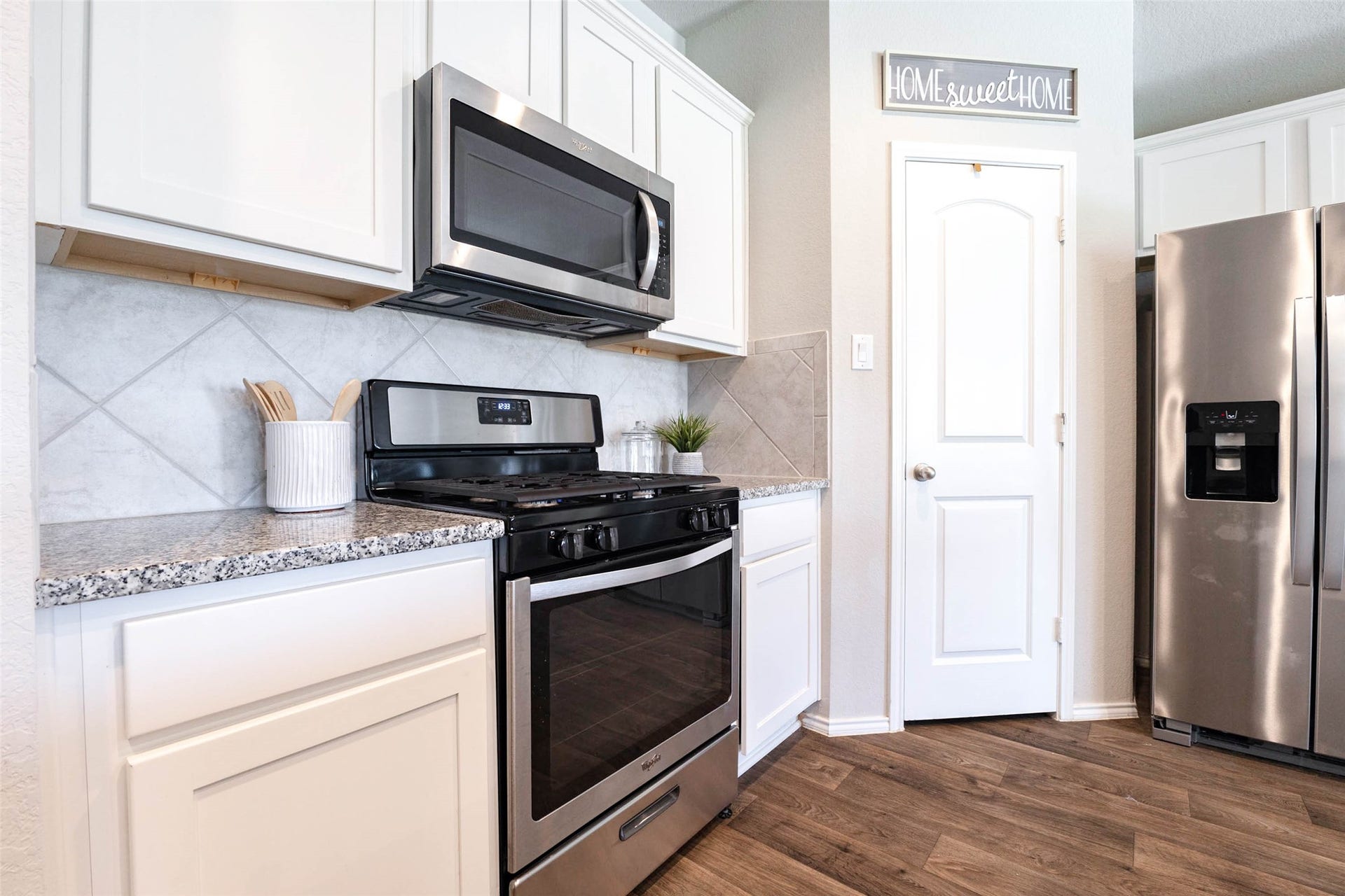 15303 Dinnet Berm Drive, Humble, TX 77346 The kitchen features a gas range with an oven and a built in microwave above, all finished in stainless steel. A stunning diagonal tile backsplash pairs beautifully with the granite countertops. A sizable walk in pantry provides plenty of room for storage.