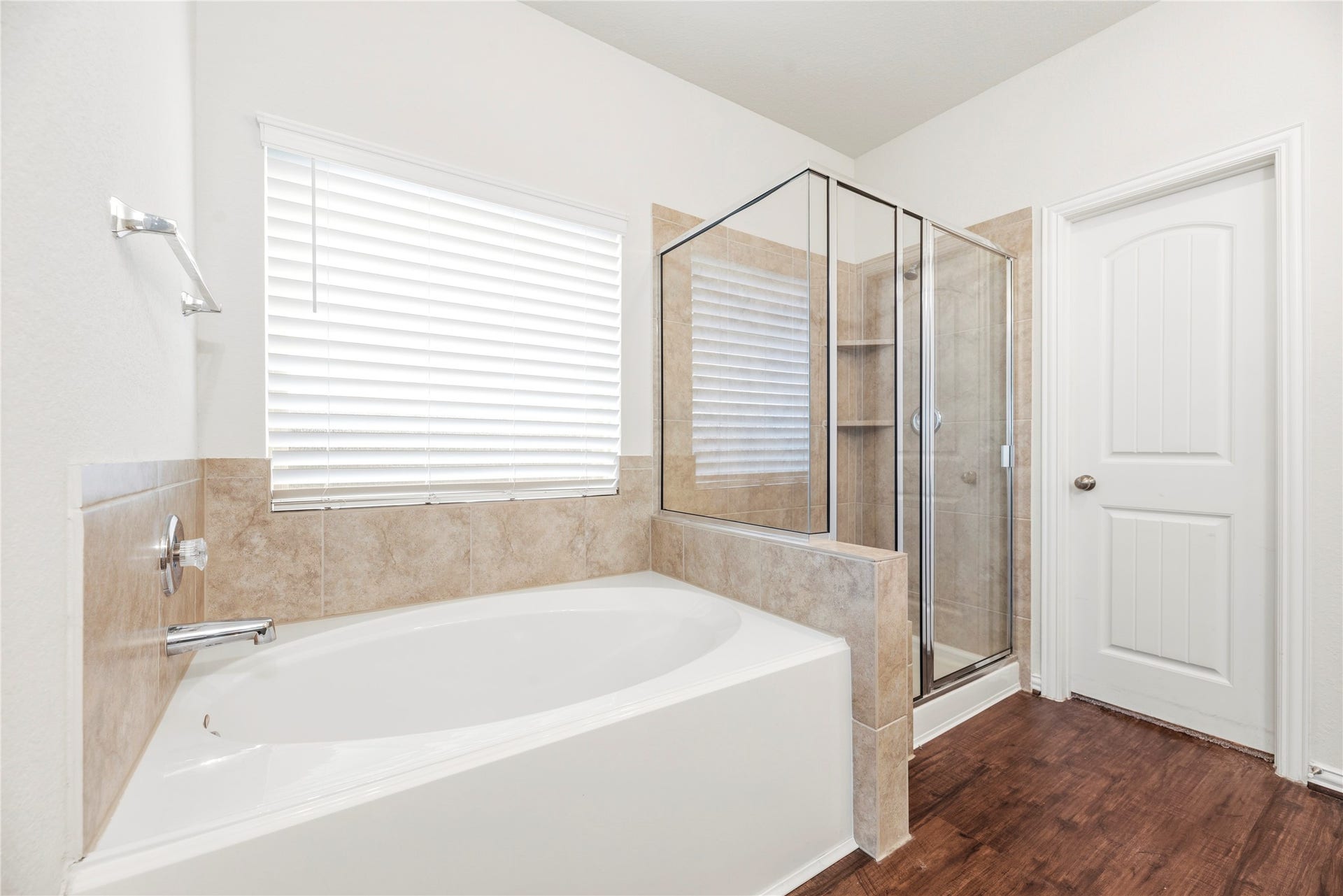 6418 Shadowbrook Hollow Trail, Katy, TX 77493 The spa-like configuration of the primary bath features a deep, integrated corner soaking tub nestled beneath a large window, paired with a dedicated glass-enclosed walk-in shower stall lined in timeless tile.