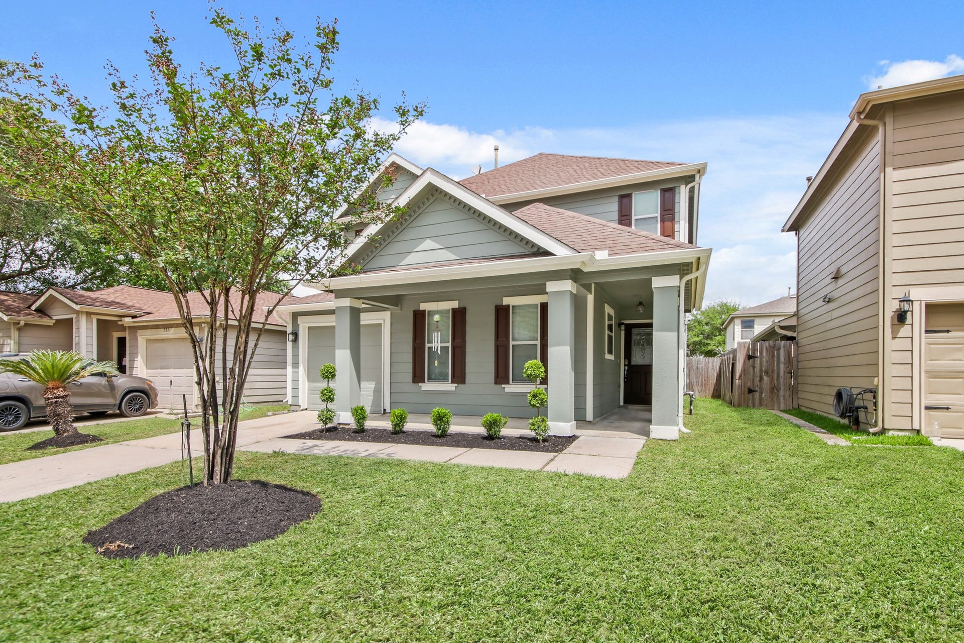 255 Silky Leaf Drive, Houston, TX 77073 A neatly landscaped front yard is highlighted by a central tree and trimmed shrubs.