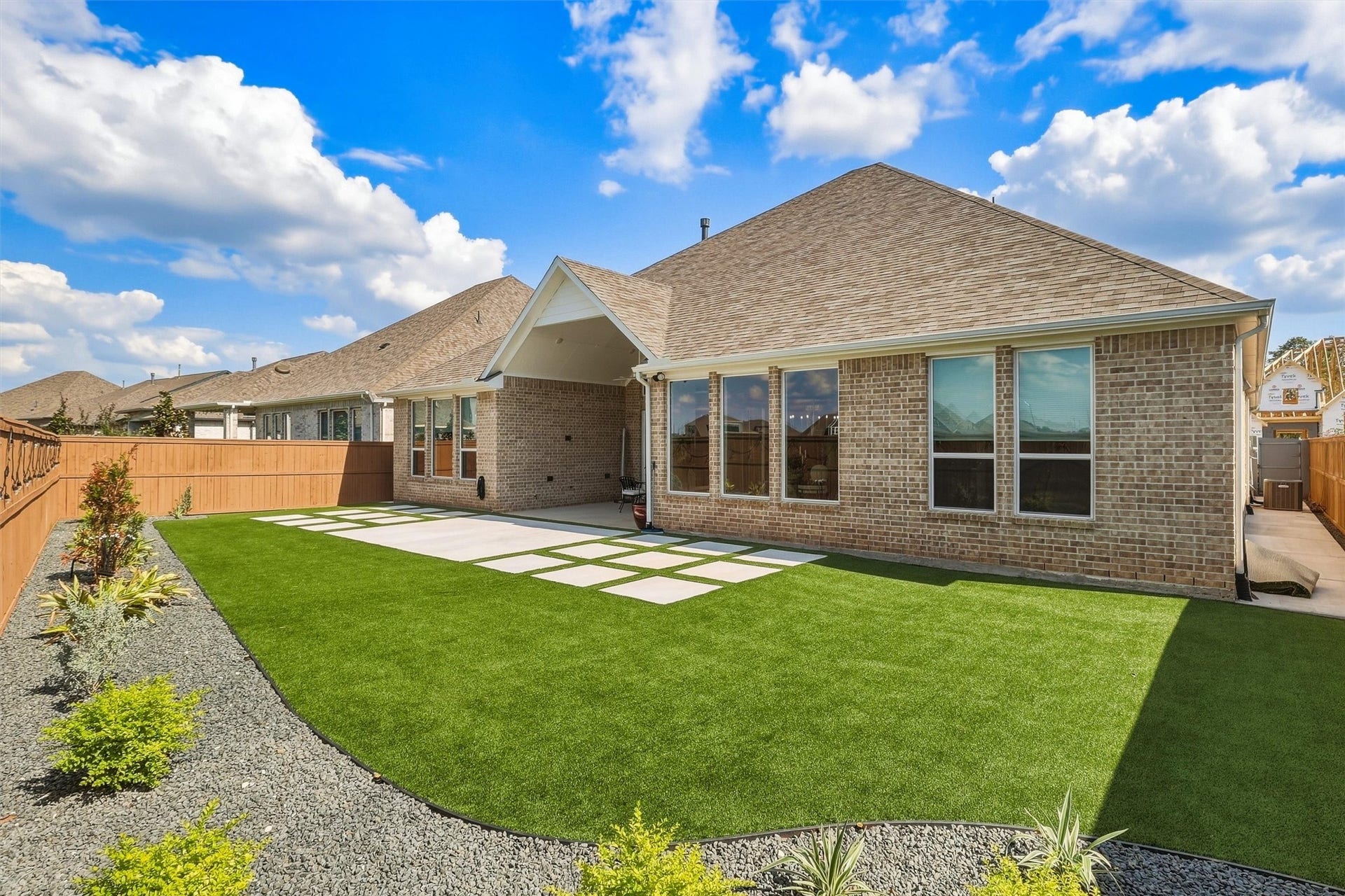Stunning backyard with a spacious covered patio, perfect for outdoor dining and entertaining, surrounded by a beautifully updated landscaped turfed lawn and modern design elements.