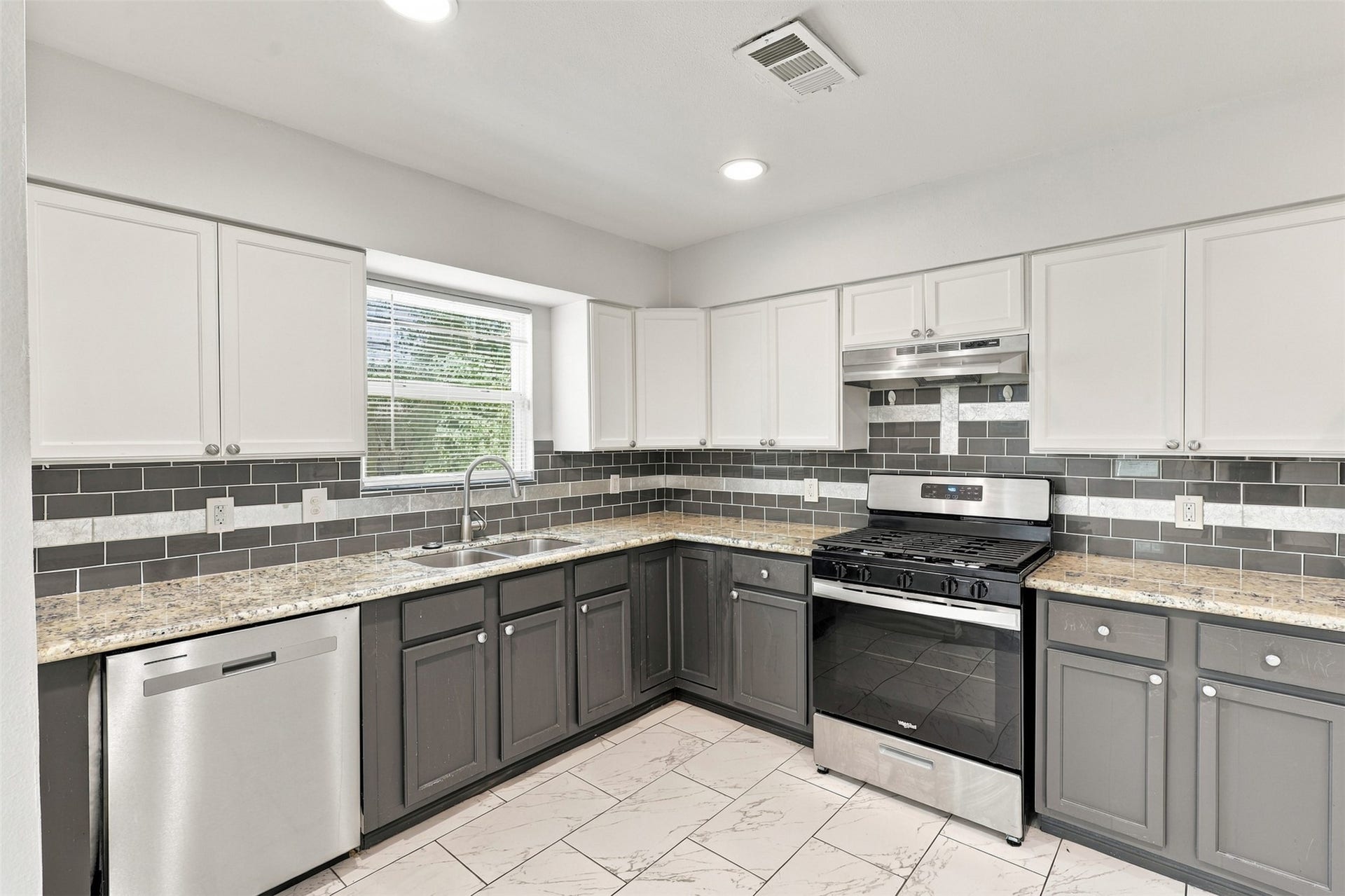 What a lovely kitchen! Featuring beautiful granite countertops, crisp white upper cabinets, rich dark lower cabinetry, stainless steel appliances, and a stylish backsplash, this kitchen offers plenty of workspace and storage for preparing all your favorite meals. A wonderful blend of charm and functionality!