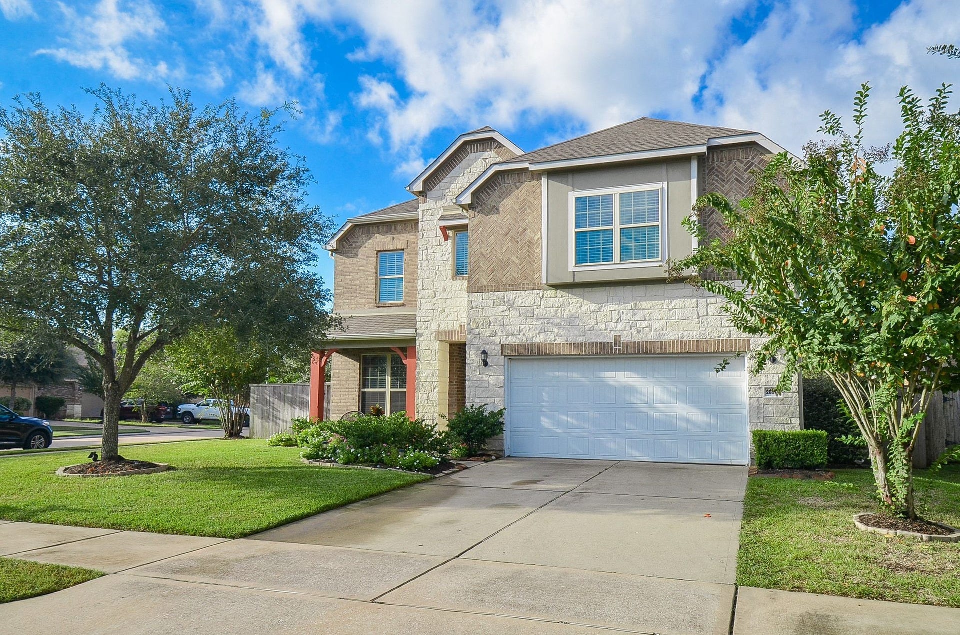 28503 Pleasant Forest Drive, Katy, TX 77494 Beautiful landscaping and a charming front covered porch.