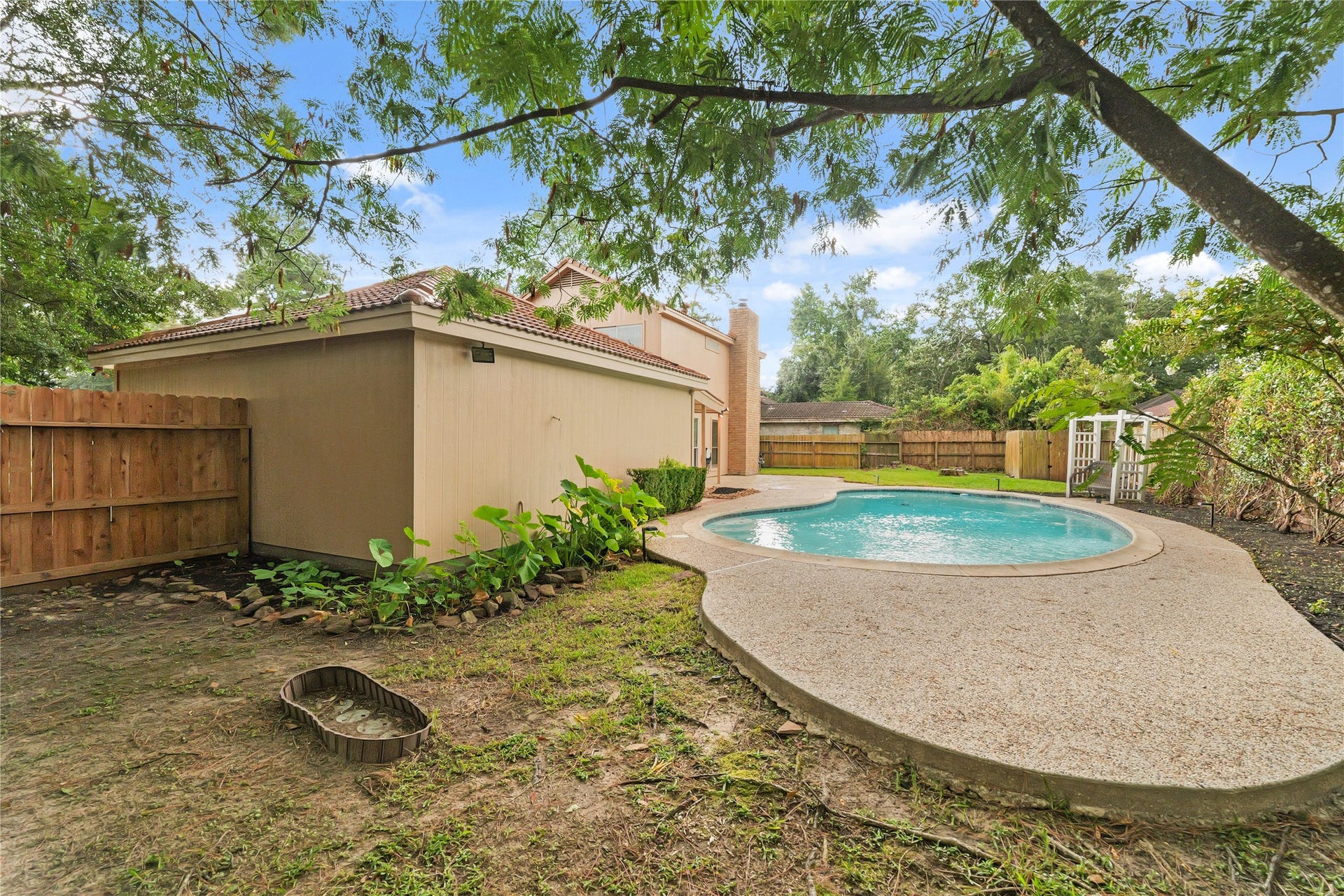 Corner view of backyard and pool
