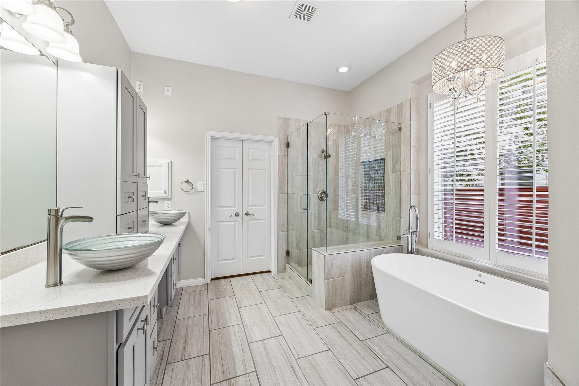 106 W Arbor Camp Circle, Spring, TX 77389 Tastefull all white sleek modern primary bath with walk in closet. Updated lighting fixtures throughout primary bath.