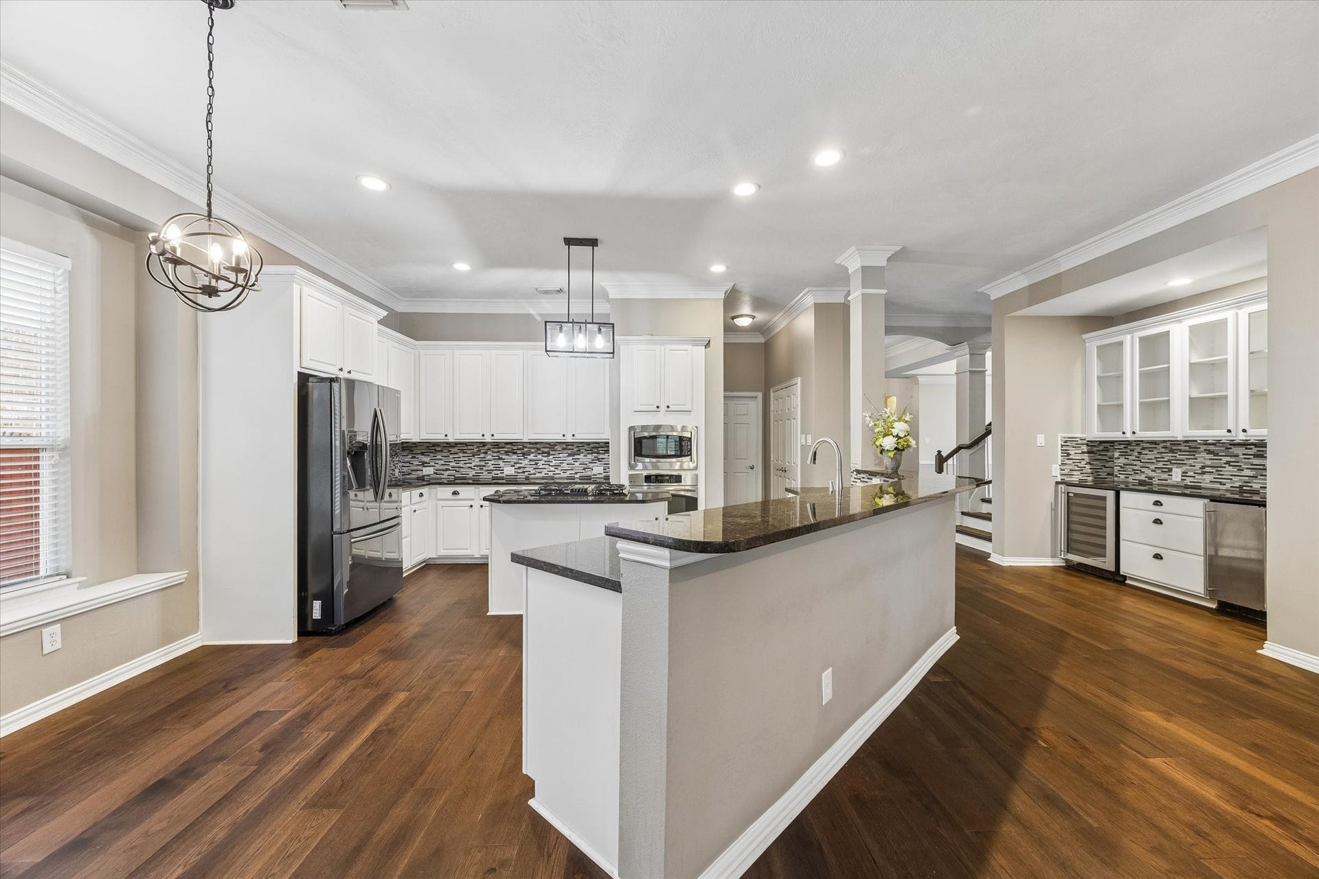 106 W Arbor Camp Circle, Spring, TX 77389 Butler's Pantry and wine fridge and ice maker to the right. Consistent Wood flooring throughout the home