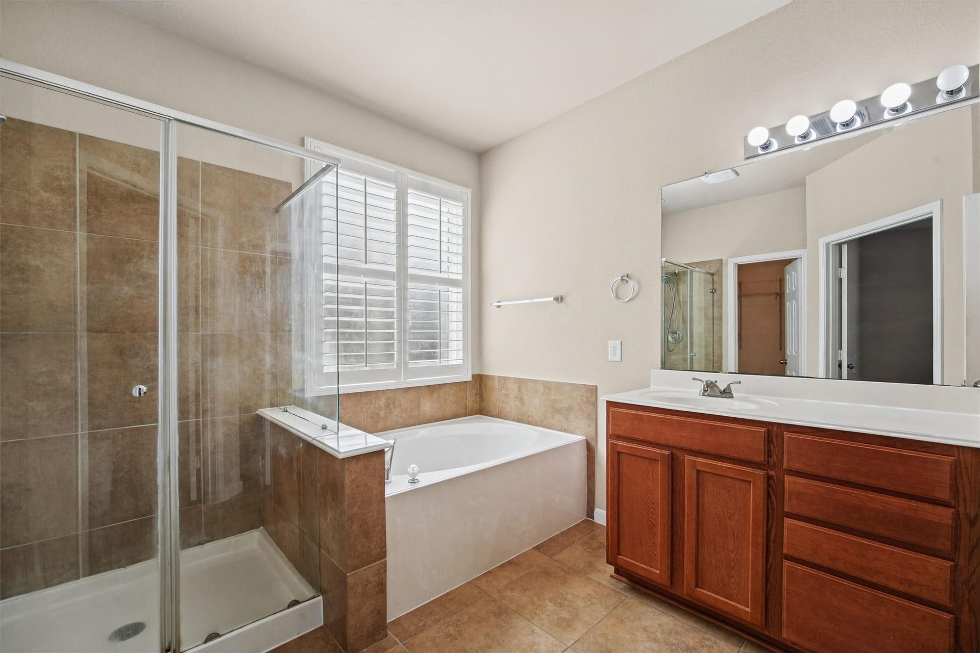 French doors lead into large primary bath complete with dual sinks, large soaking tub, and a large shower.