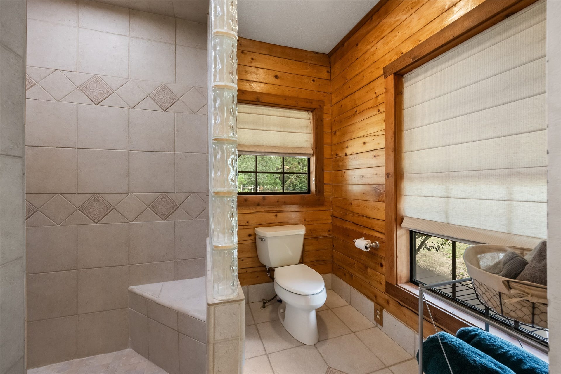 27874 Riley Road, Waller, TX 77484 The walk-in shower features decorative tile surrounds and a glass block divider, while two windows bring in natural light and peaceful views of the outdoors.