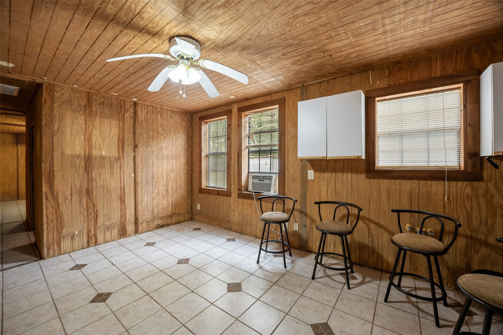 27874 Riley Road, Waller, TX 77484 Warm wood walls and ceilings give this spacious tack room rustic character, while easy care tile floors, multiple windows and a ceiling fan add everyday comfort.