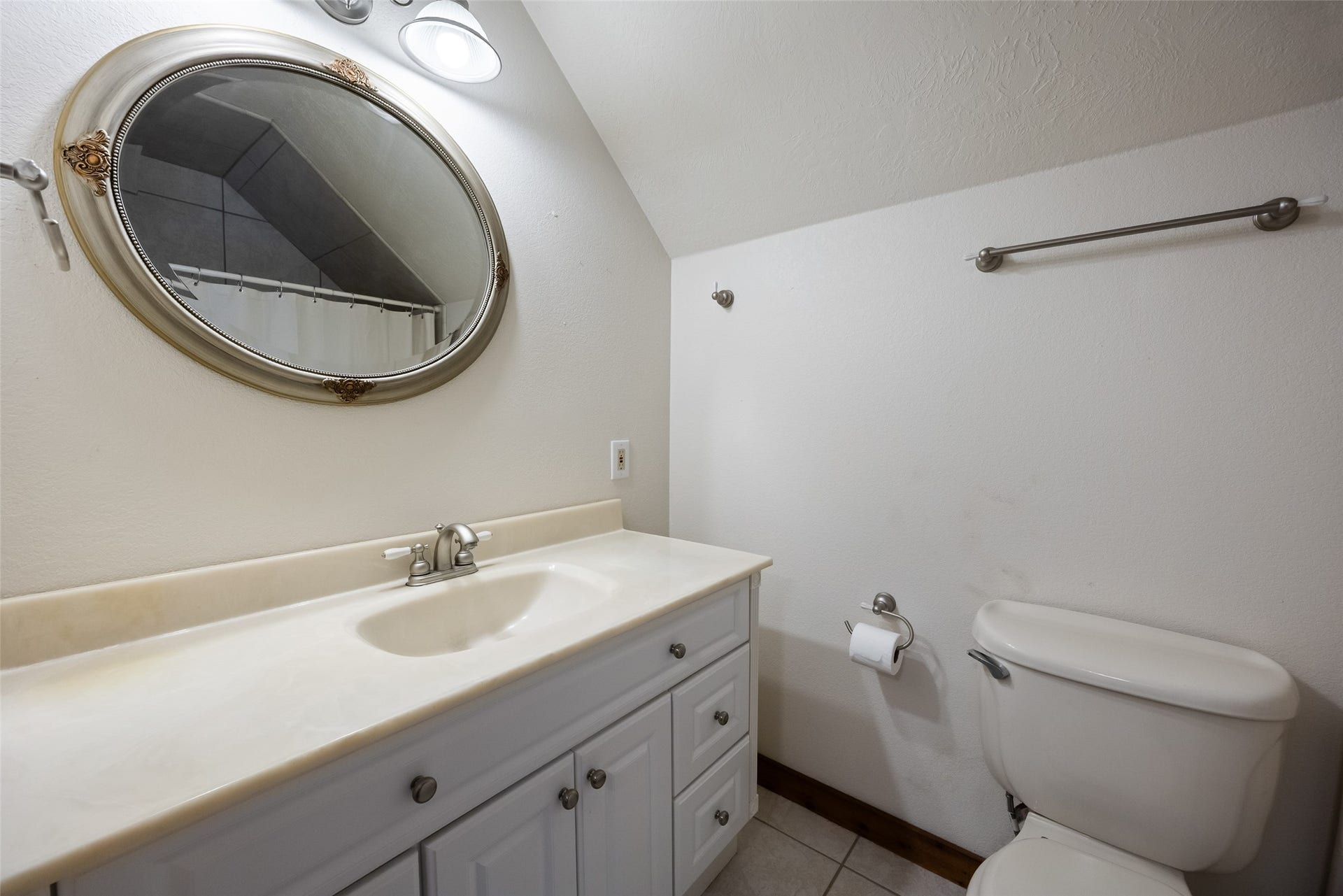 27874 Riley Road, Waller, TX 77484 The upstairs full bathroom features a crisp white vanity with plenty of cabinet storage, a spacious countertop, decorative mirror and tile flooring.