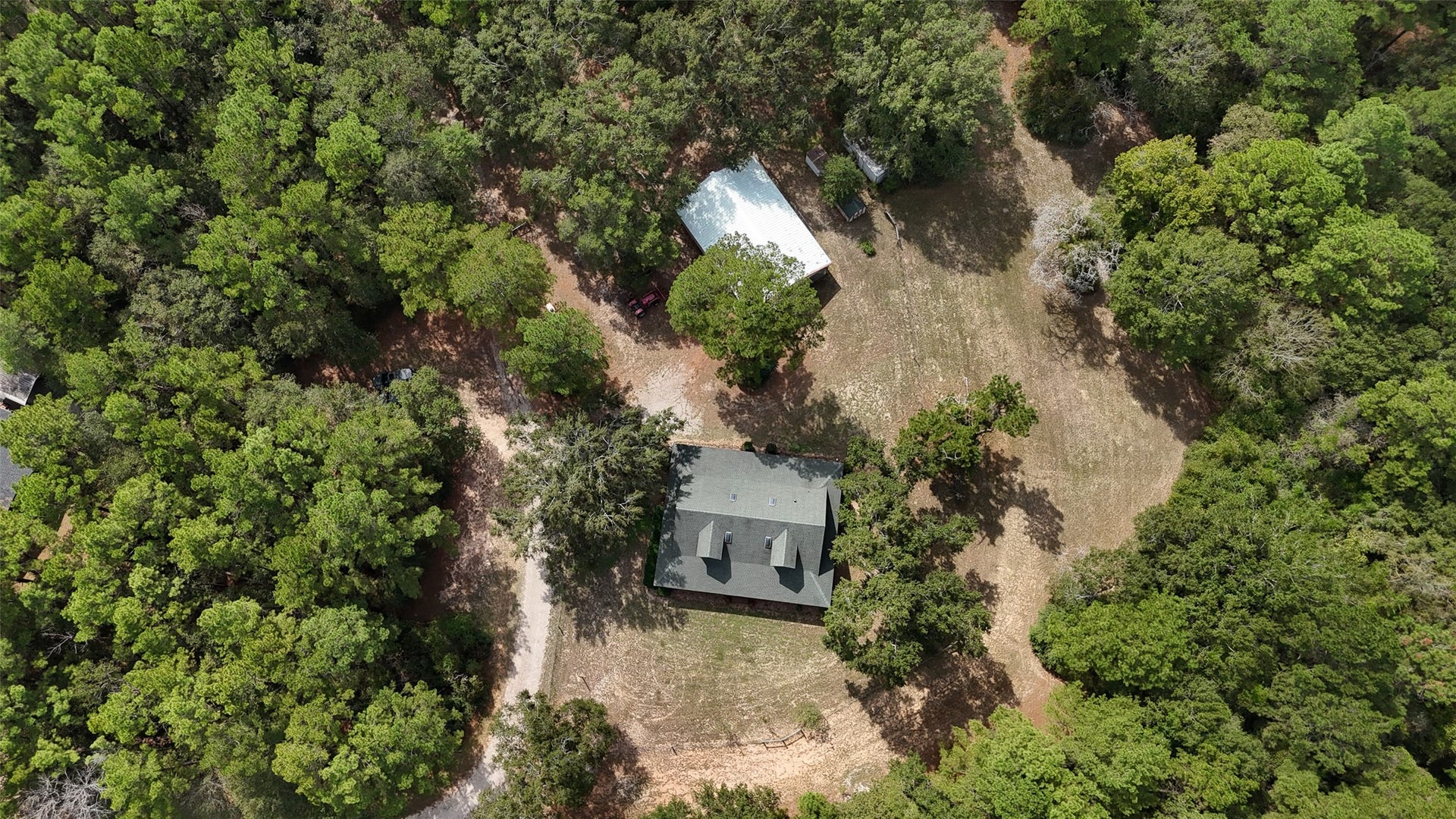 27874 Riley Road, Waller, TX 77484 Take a look from above! Nestled among beautiful mature trees, this charming log cabin sits on 18+ acres with plenty of room to roam. A spacious metal barn with a workshop, two stalls and a tack room adds even more possibilities for country living.